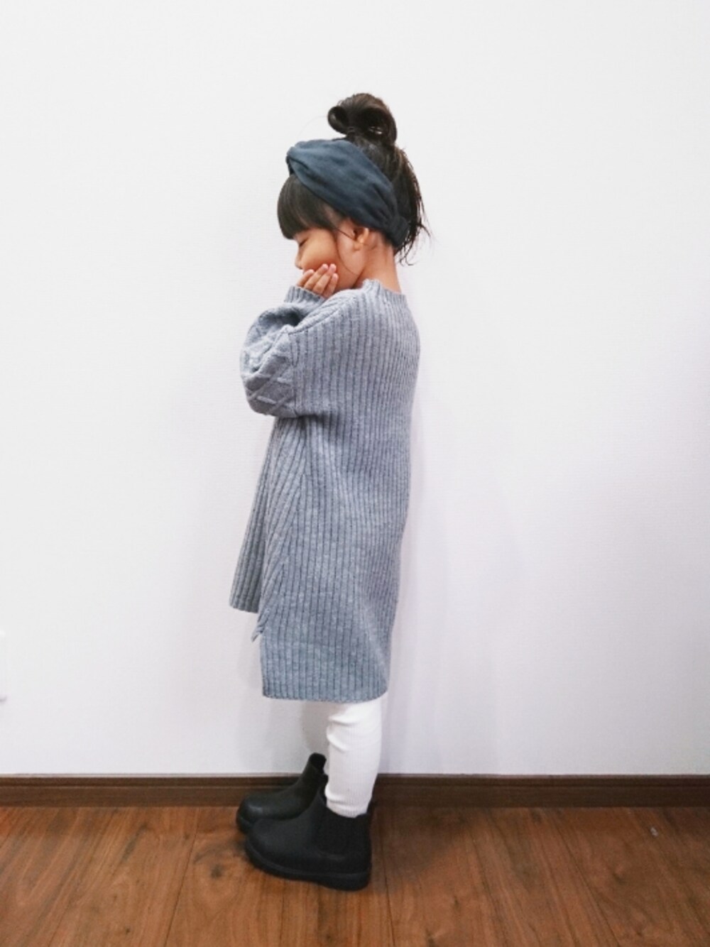 グレー系のワンピース、ブラック系のブーツを着用したキッズの秋コーディネートの1枚目の写真