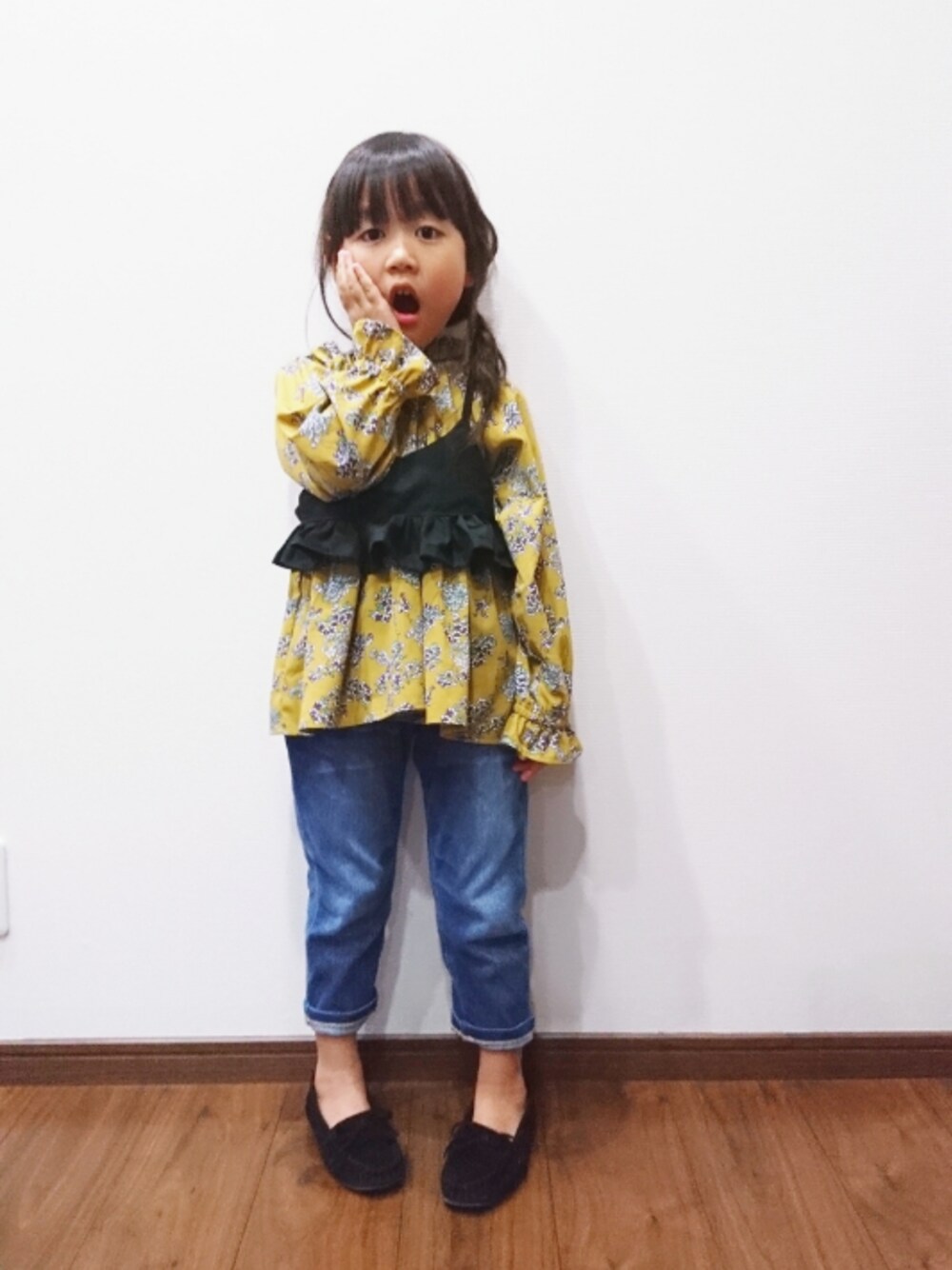 イエロー系のシャツ/ブラウス、ブラック系のキャミソール、ブルー系のデニムパンツを着用したキッズの秋コーディネートの1枚目の写真
