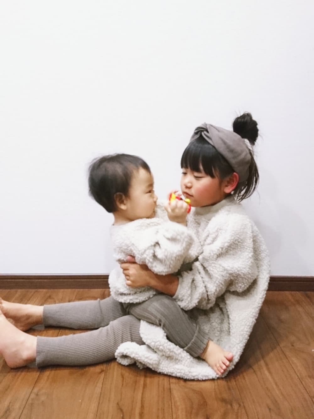 ベージュ系のトップス、ベージュ系のワンピース、ブラウン系のレギンス/スパッツを着用したキッズの秋コーディネートの1枚目の写真