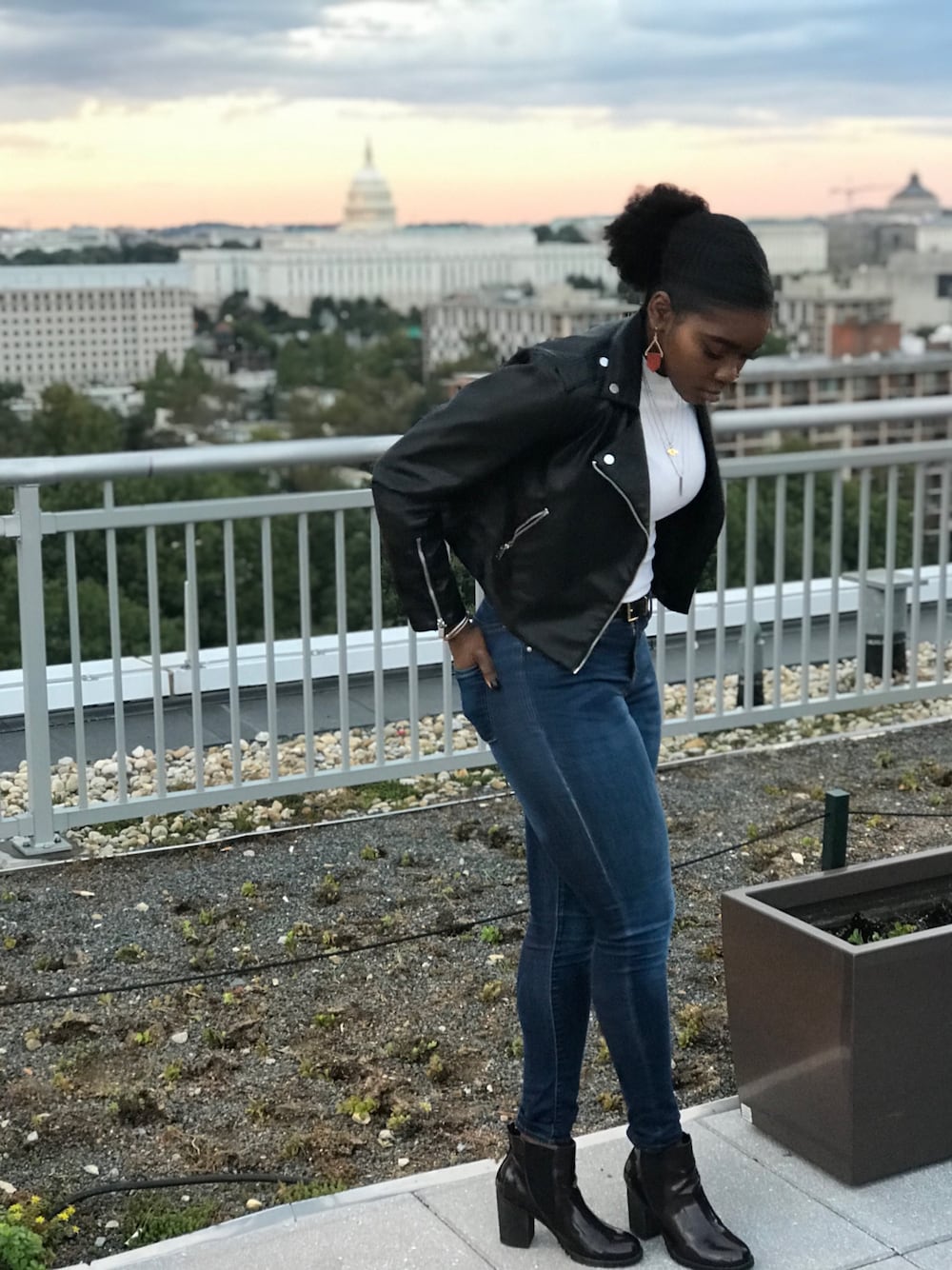 ブラック系のライダースジャケット、ブルー系のデニムパンツ、レッド系のブーティを着用したレディースの冬コーディネートの1枚目の写真