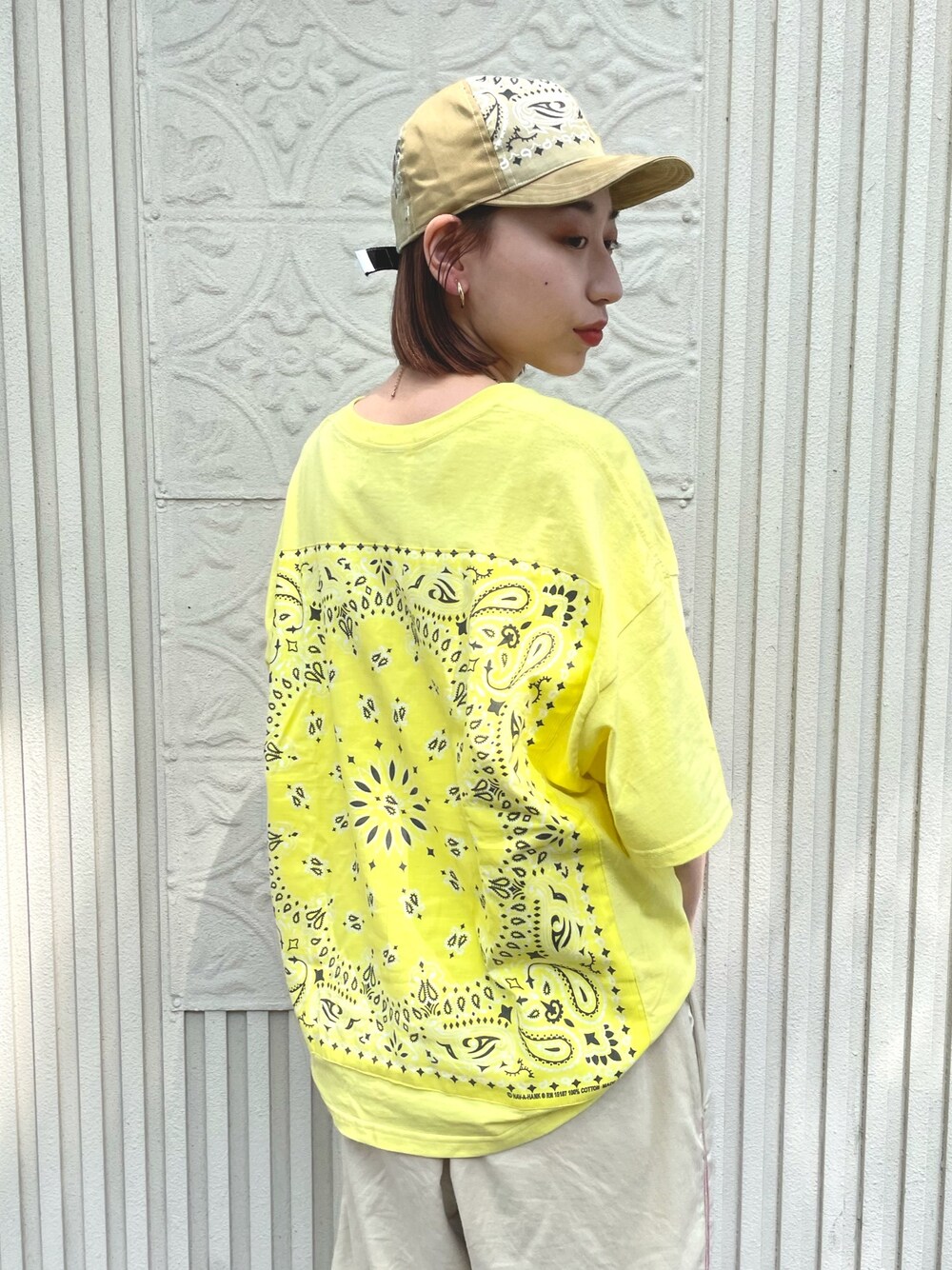 イエロー系のTシャツ/カットソー、ベージュ系のキャップを着用したレディースの春コーディネートの1枚目の写真