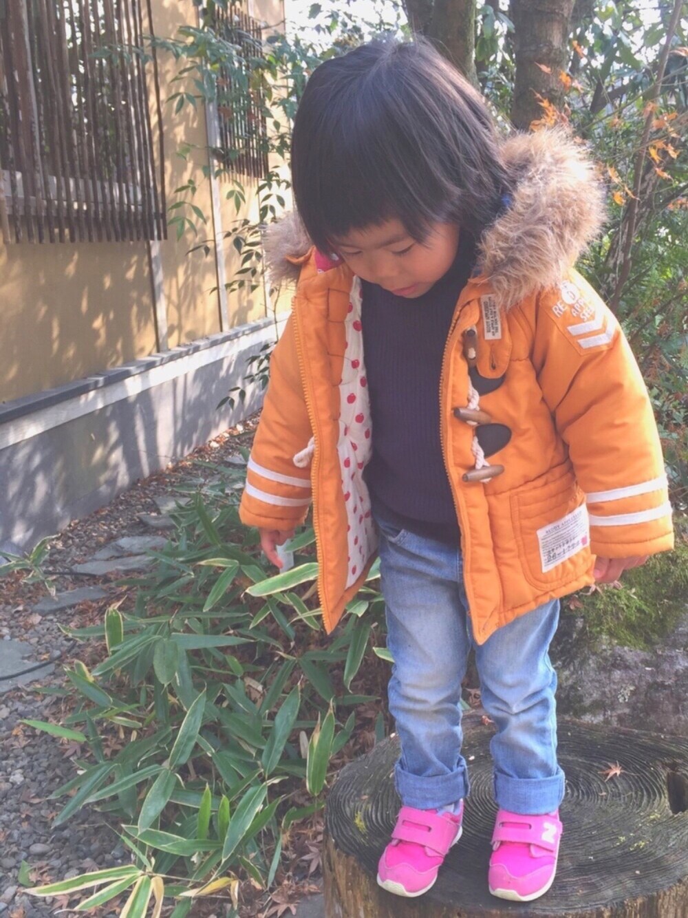 イエロー系のその他アウター、ブルー系のニット/セーター、ブルー系のデニムパンツを着用したキッズの冬コーディネートの1枚目の写真