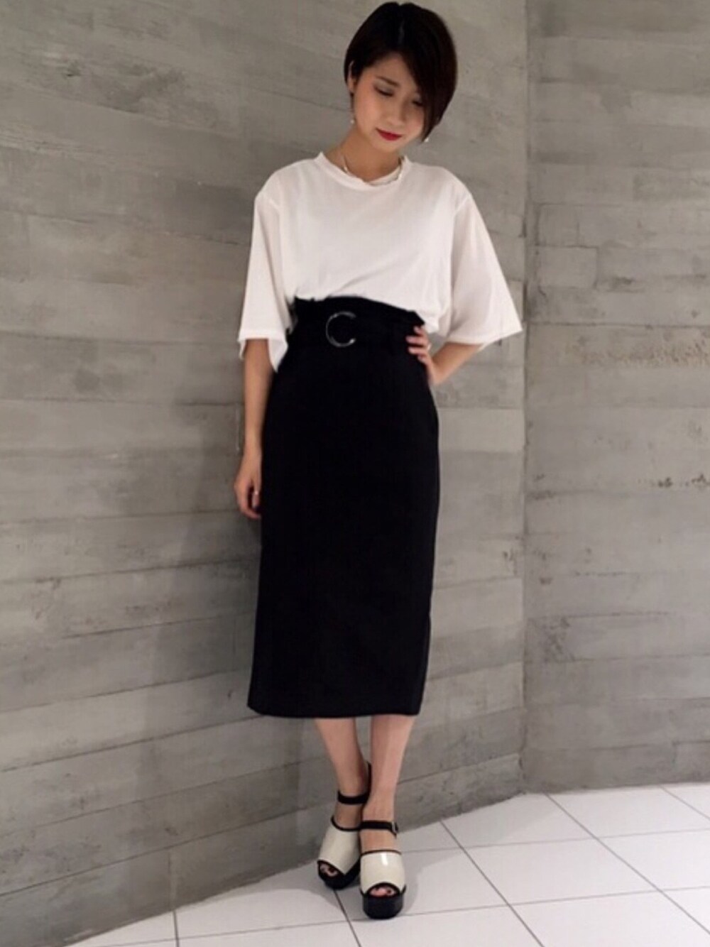 ホワイト系のサンダル、ブラック系のスカート、ホワイト系のTシャツ/カットソーを着用したレディースの夏コーディネートの1枚目の写真