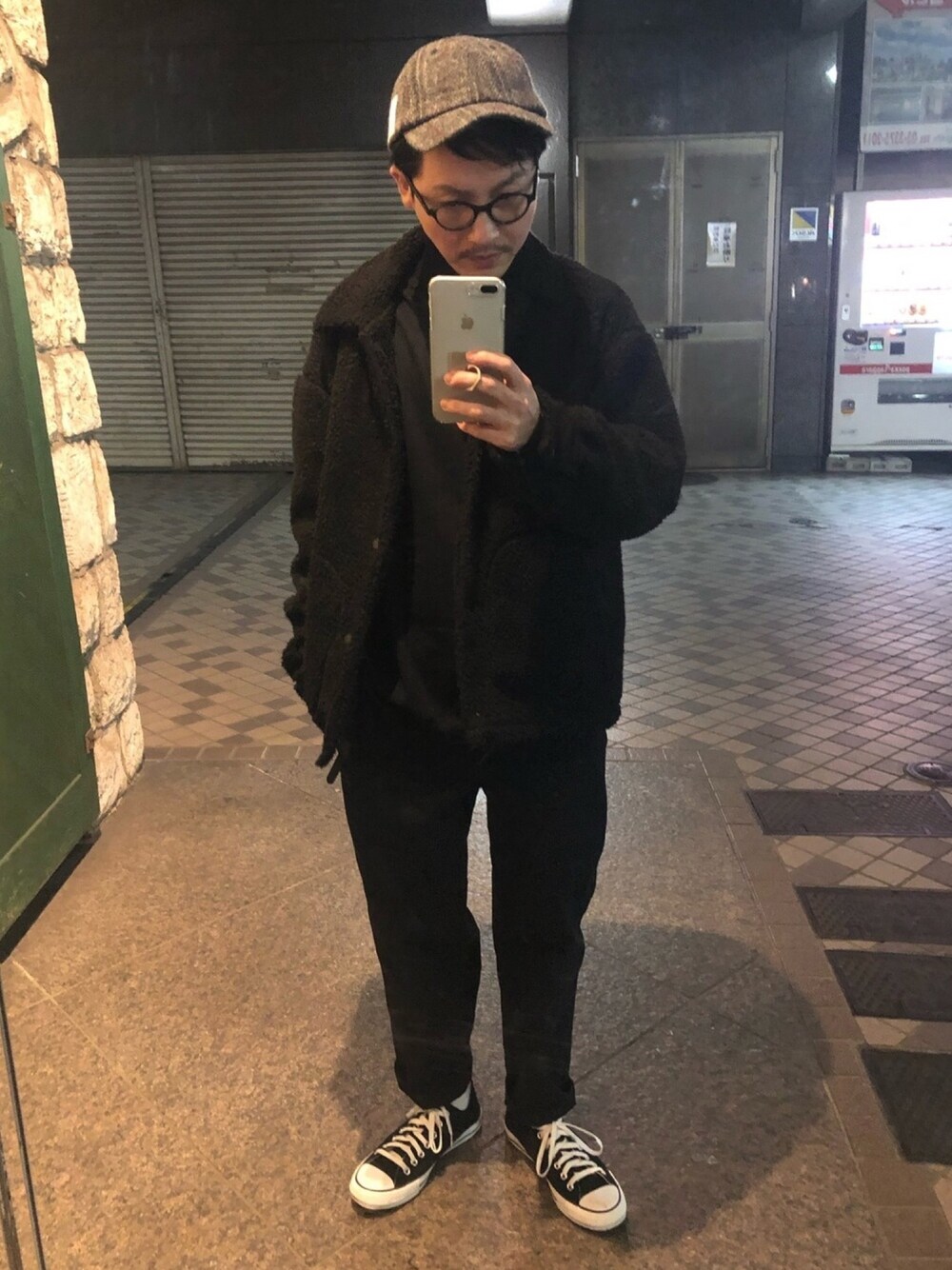 ブラック系のブルゾン、ブラック系のニット/セーター、ホワイト系のスニーカーを着用したメンズの冬コーディネートの1枚目の写真