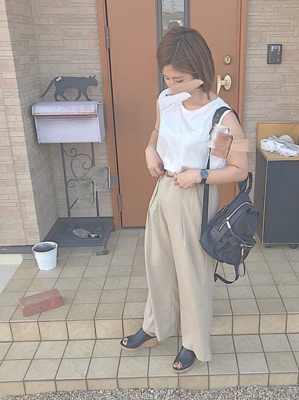 ホワイト系のTシャツ/カットソー、ベージュ系のパンツ、ブラック系のバックパック/リュックを着用したレディースの夏コーディネートの1枚目の写真