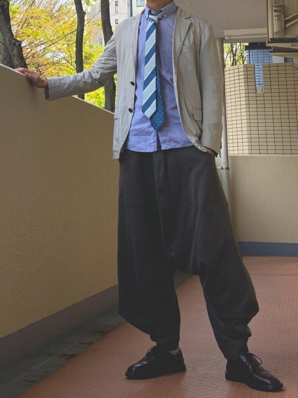 グレー系のその他パンツ、ブルー系のネクタイを着用したメンズの春コーディネートの1枚目の写真