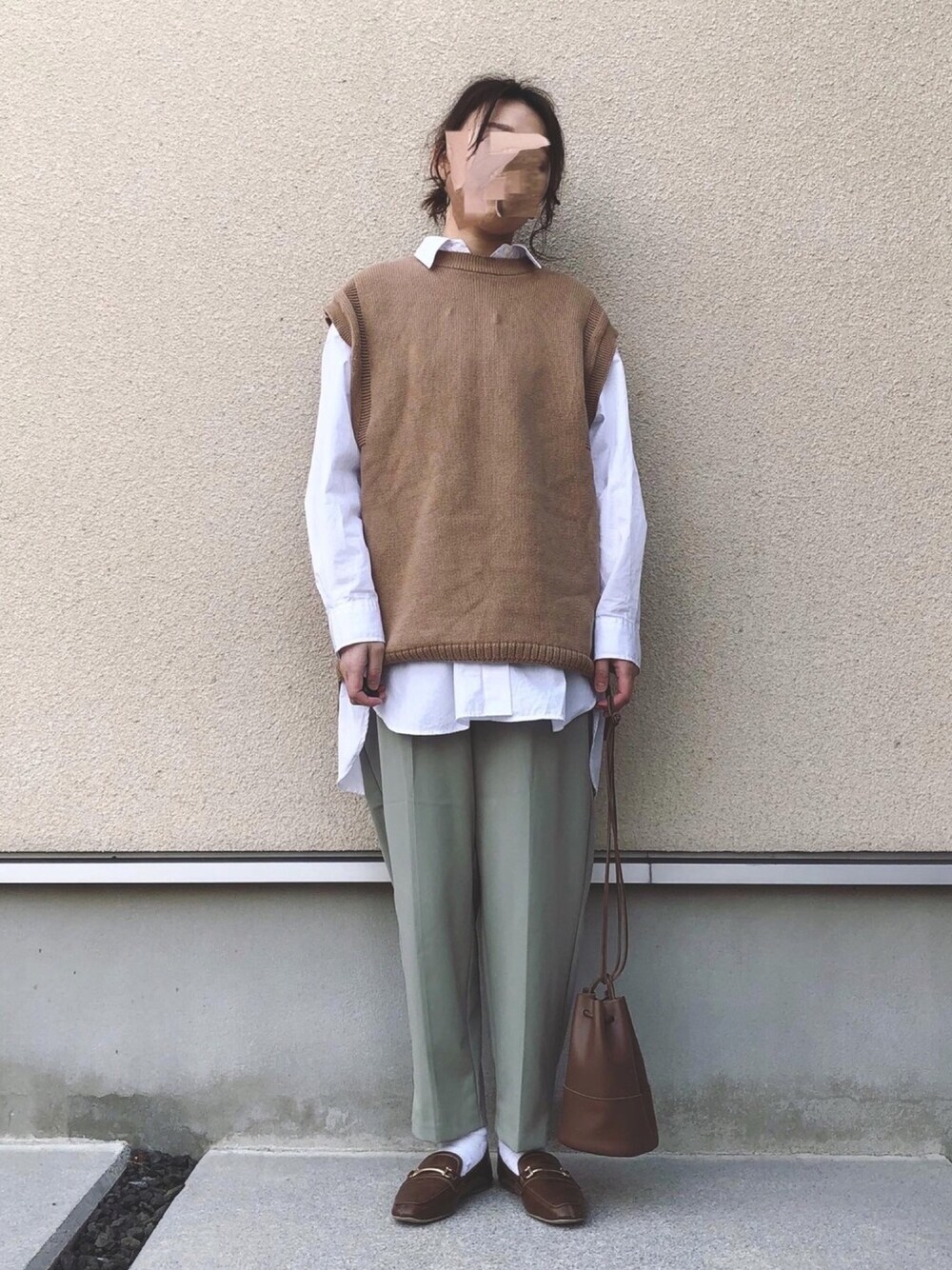 ベージュ系のベスト、ホワイト系のシャツ/ブラウス、グリーン系のパンツを着用したレディースの冬コーディネートの1枚目の写真