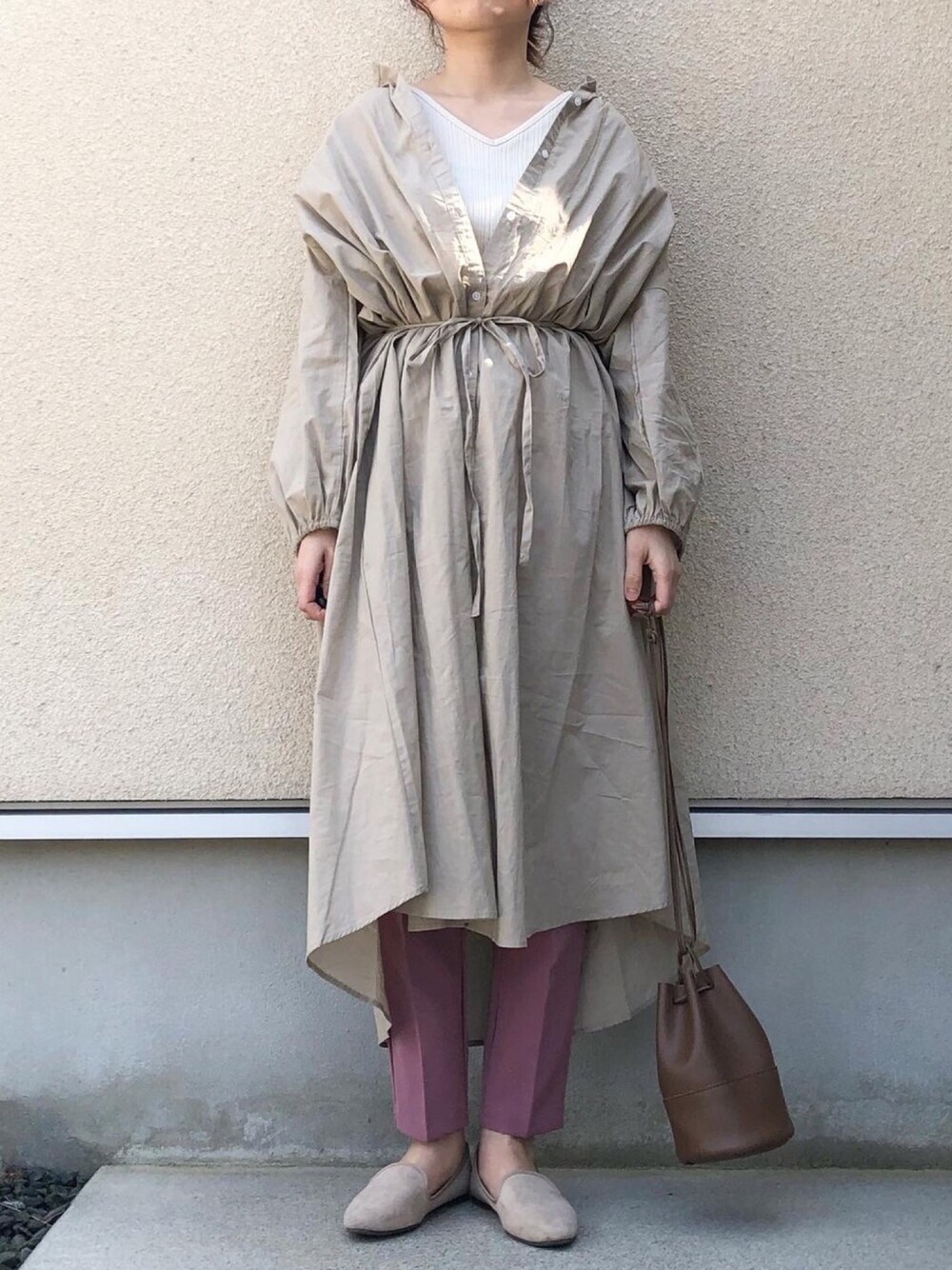 ベージュ系のシャツワンピース、ホワイト系のタンクトップ、ピンク系のパンツを着用したレディースの春コーディネートの1枚目の写真