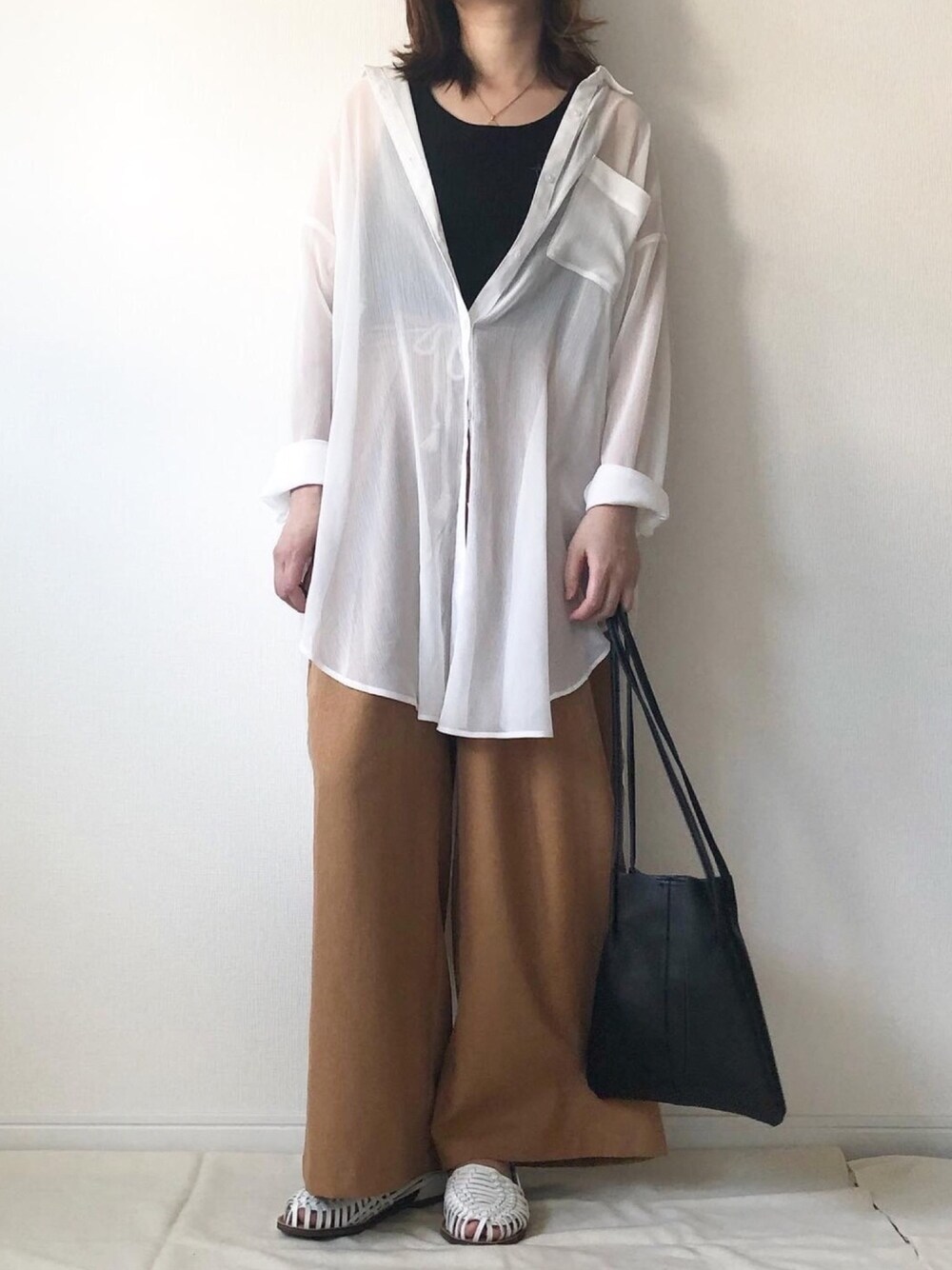 ホワイト系のシャツ/ブラウス、ブラック系のタンクトップ、ブラウン系のパンツを着用したレディースの春コーディネートの1枚目の写真