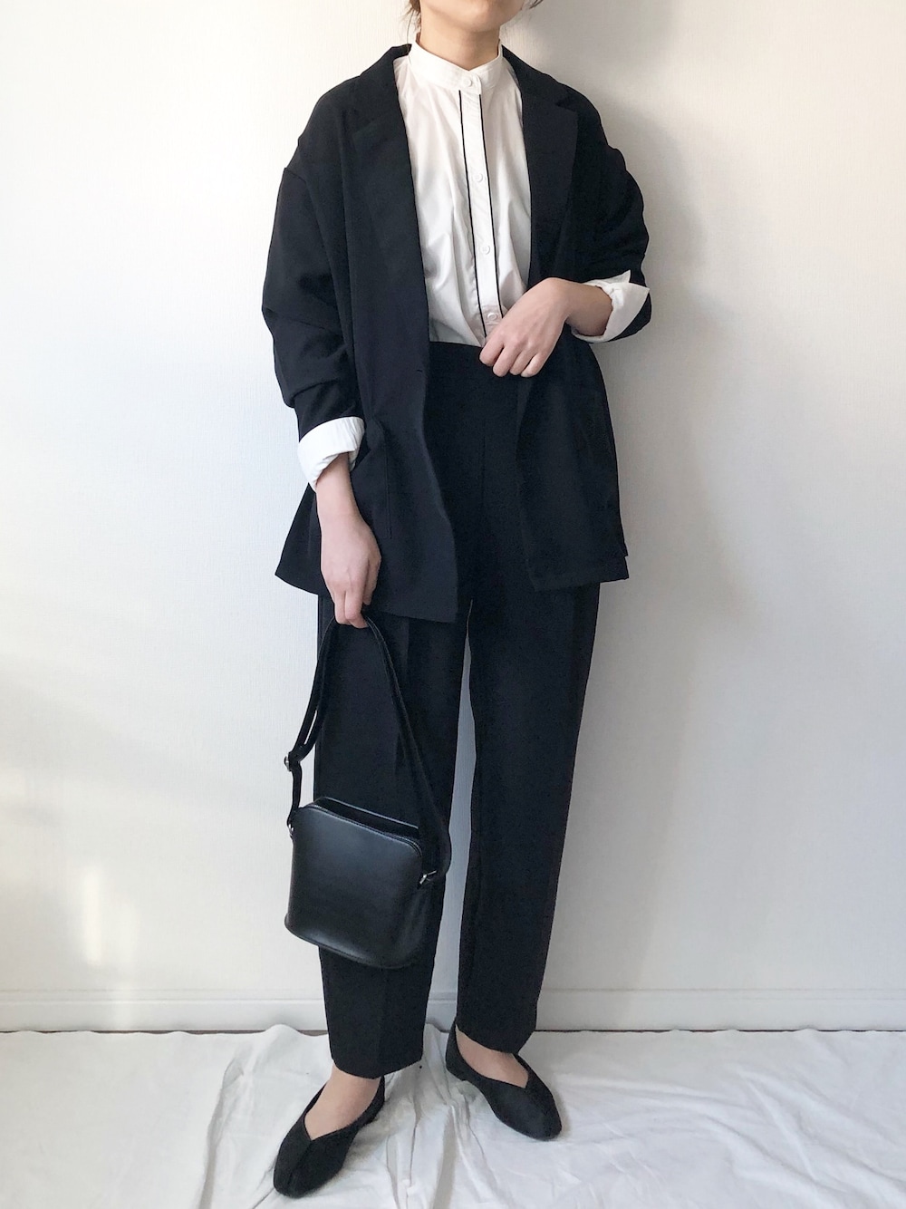 ブラック系のジャケット/アウター、ホワイト系のシャツ/ブラウス、ブラック系のパンツを着用したレディースの春コーディネートの1枚目の写真