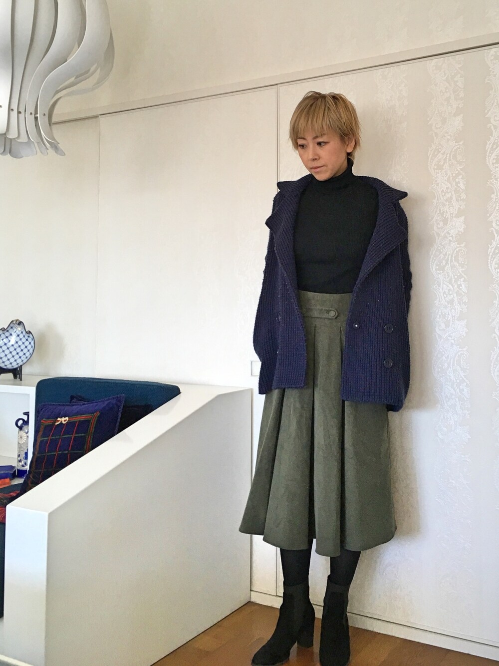 ブルー系のその他アウター、グリーン系のスカート、ブラック系のブーツを着用したレディースの冬コーディネートの1枚目の写真