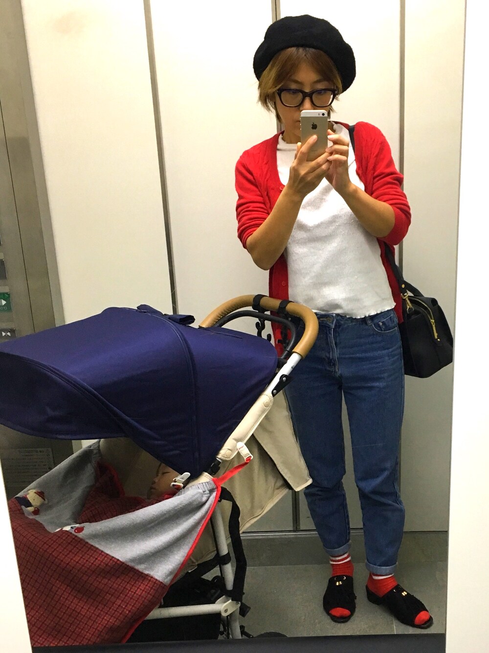 レッド系のカーディガン/ボレロ、ホワイト系のTシャツ/カットソー、ブルー系のデニムパンツを着用したレディースの秋コーディネートの1枚目の写真