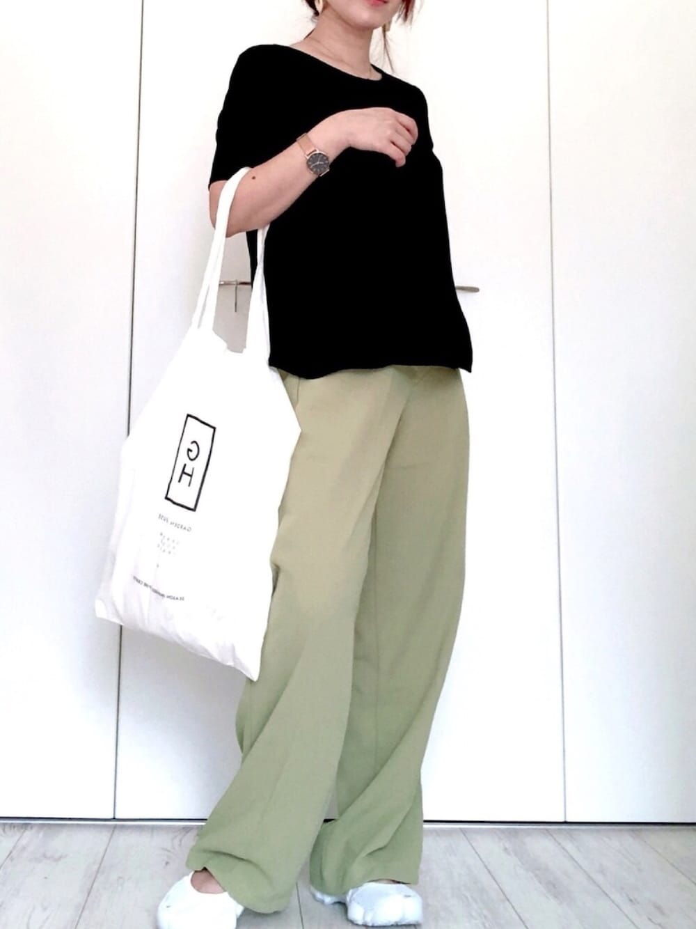 グリーン系のスラックス、ブラック系のTシャツ/カットソー、ブラック系のスニーカーを着用したレディースの夏コーディネートの1枚目の写真