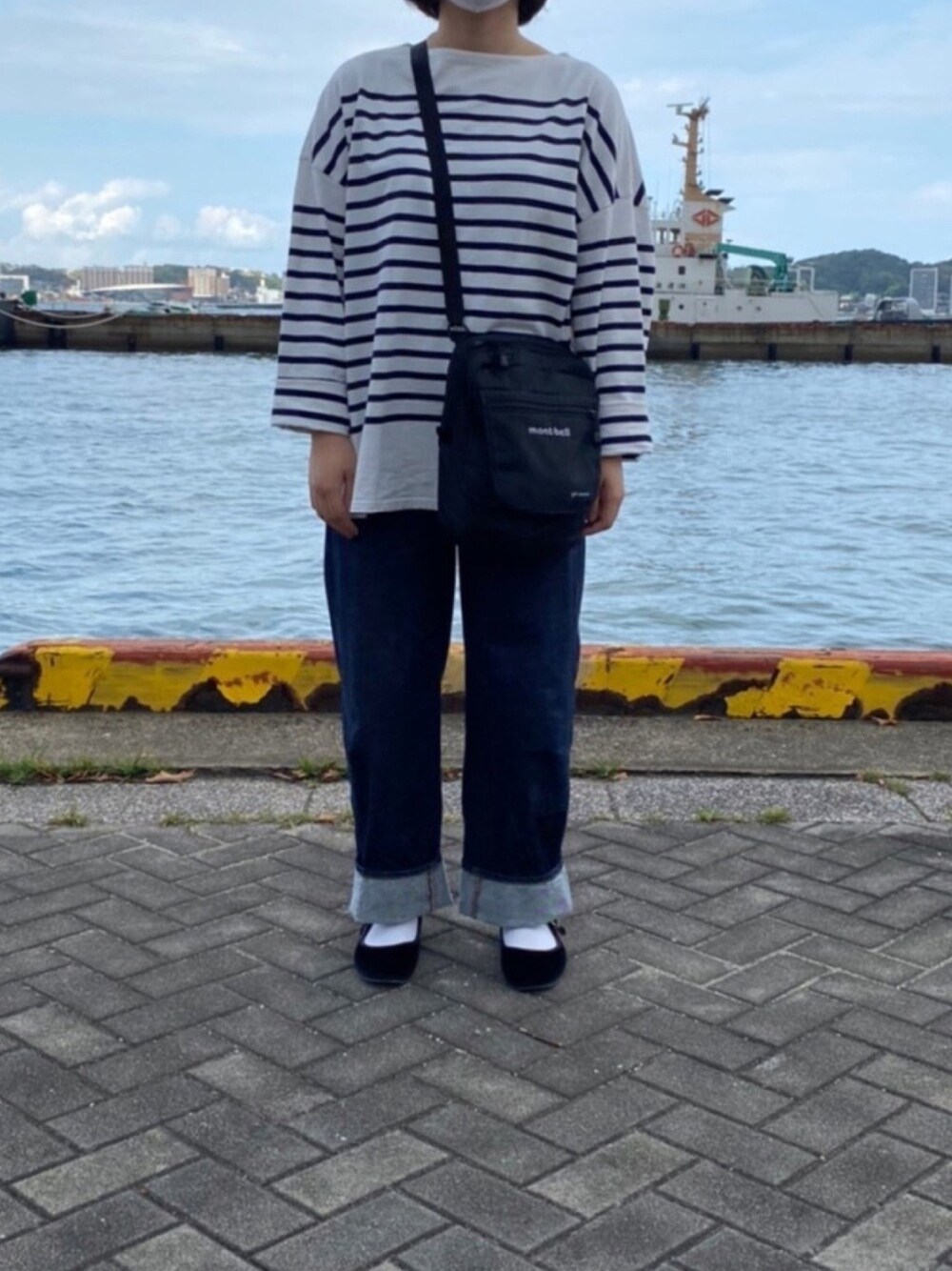 ブルー系のデニムパンツ、ブラック系のバレエシューズ、ブルー系のTシャツ/カットソーを着用したレディースの秋コーディネートの1枚目の写真