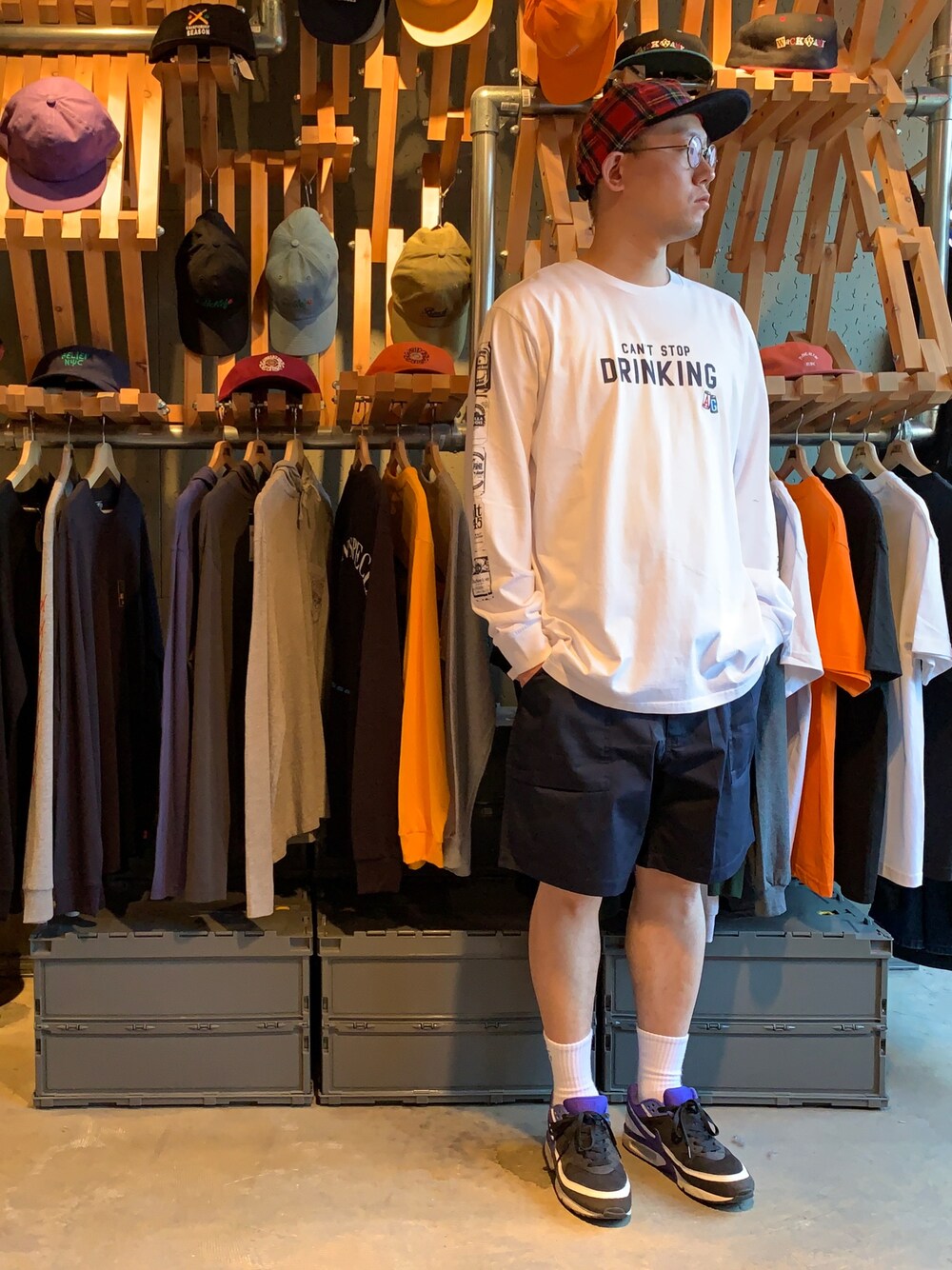 ホワイト系のTシャツ/カットソー、ブルー系のチノパンツ、レッド系のキャップを着用したメンズの春コーディネートの1枚目の写真