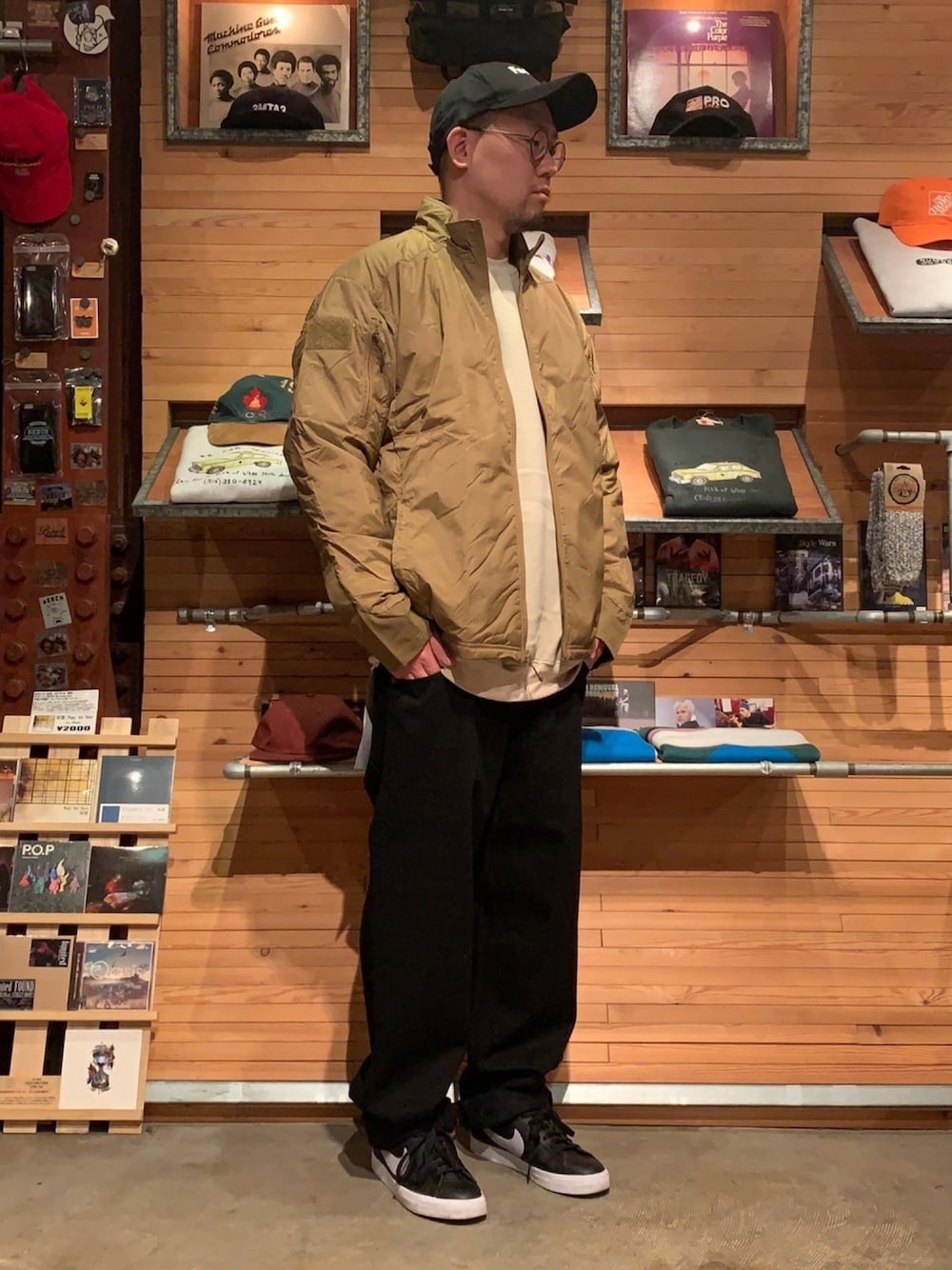 ブラウン系のミリタリージャケット、ブラック系のデニムパンツ、ブラック系のキャップを着用したメンズの春コーディネートの1枚目の写真