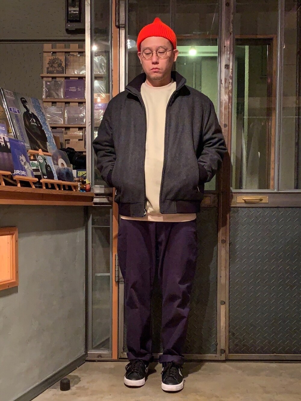 グレー系のジャケット/アウター、ブルー系のチノパンツ、オレンジ系のニットキャップ/ビーニーを着用したメンズの春コーディネートの1枚目の写真