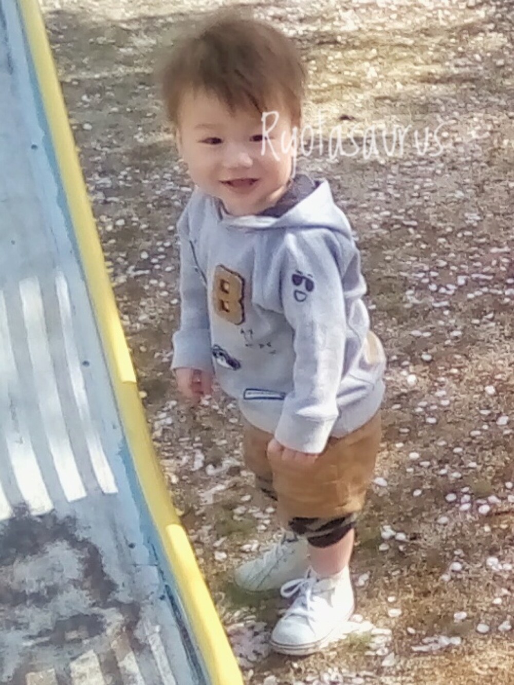 グレー系のパーカー、ベージュ系のパンツ、ホワイト系のスニーカーを着用したキッズの春コーディネートの1枚目の写真