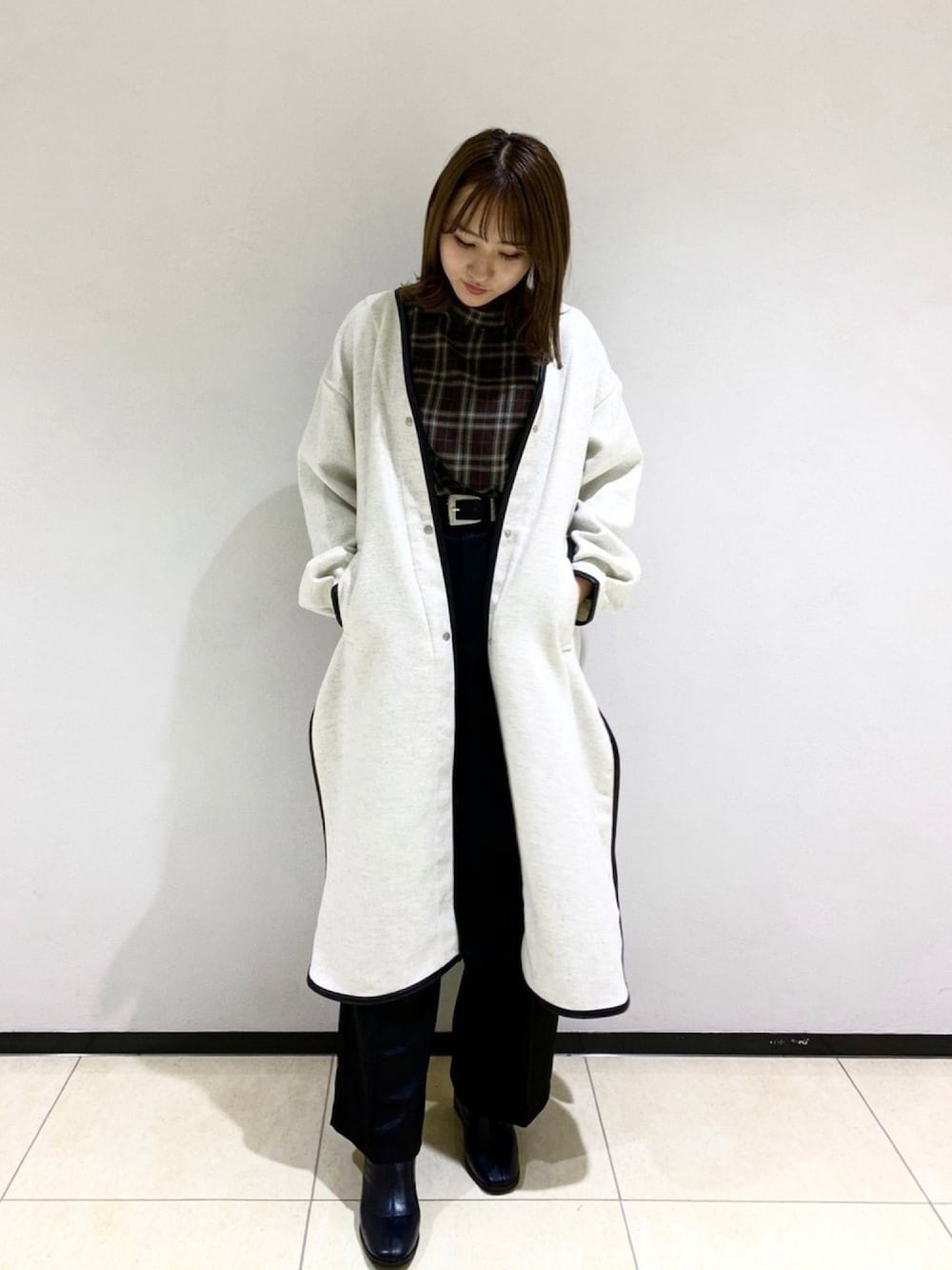 ブラウン系のシャツ/ブラウス、ベージュ系のダウンジャケット/コート、ブラック系のスラックスを着用したレディースの秋コーディネートの1枚目の写真