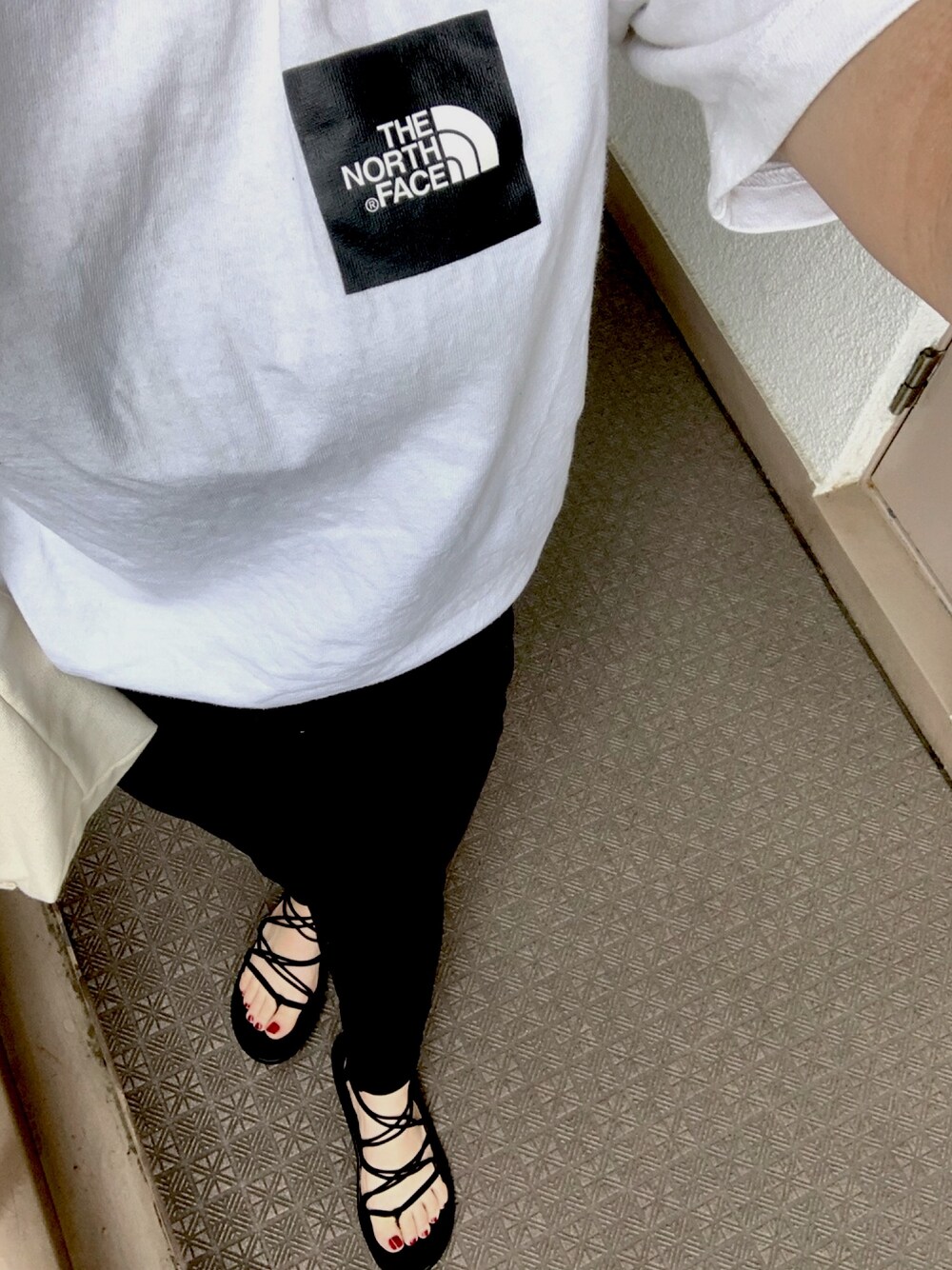 ホワイト系のTシャツ/カットソー、ホワイト系のデニムパンツ、ブラック系のサンダルを着用したレディースの夏コーディネートの1枚目の写真