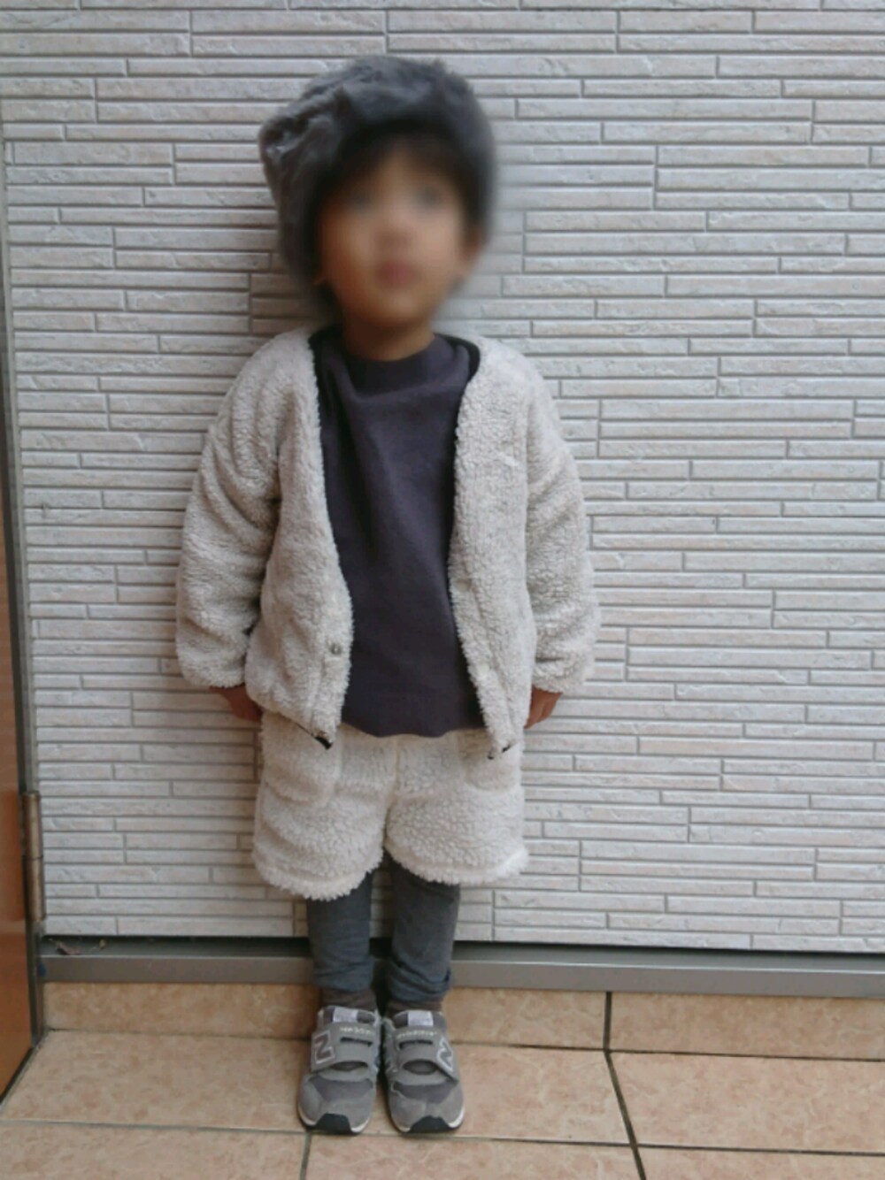 ホワイト系のノーカラージャケット、ホワイト系のスウェットパンツを着用したキッズの冬コーディネートの1枚目の写真