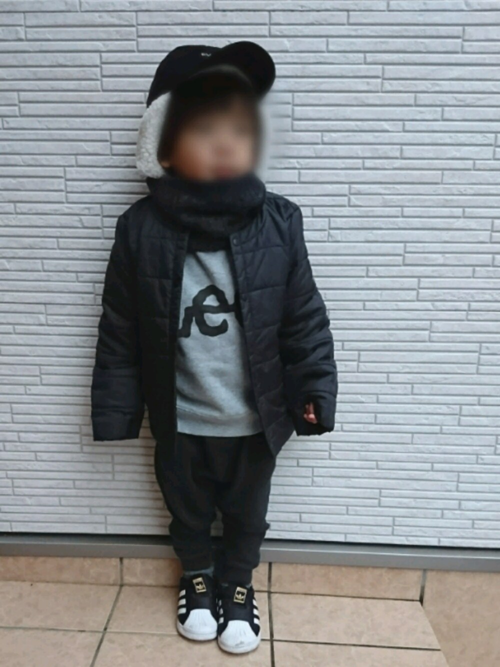 グレー系のスウェット、ブラック系のその他パンツ、ブラック系のスリッポンを着用したキッズの冬コーディネートの1枚目の写真