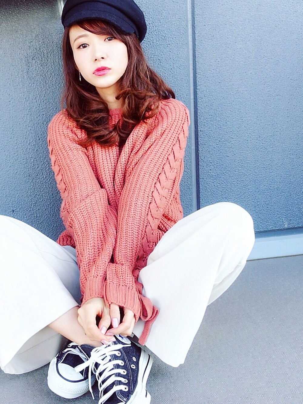 オレンジ系のニット/セーター、ホワイト系のパンツ、その他のスニーカーを着用したレディースの冬コーディネートの1枚目の写真