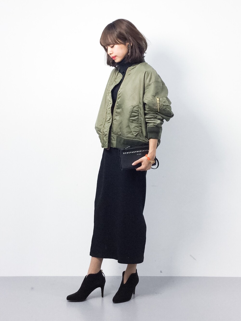 グリーン系のMA-1、ブラック系のTシャツ/カットソー、ブラック系のブーティを着用したレディースの冬コーディネートの1枚目の写真