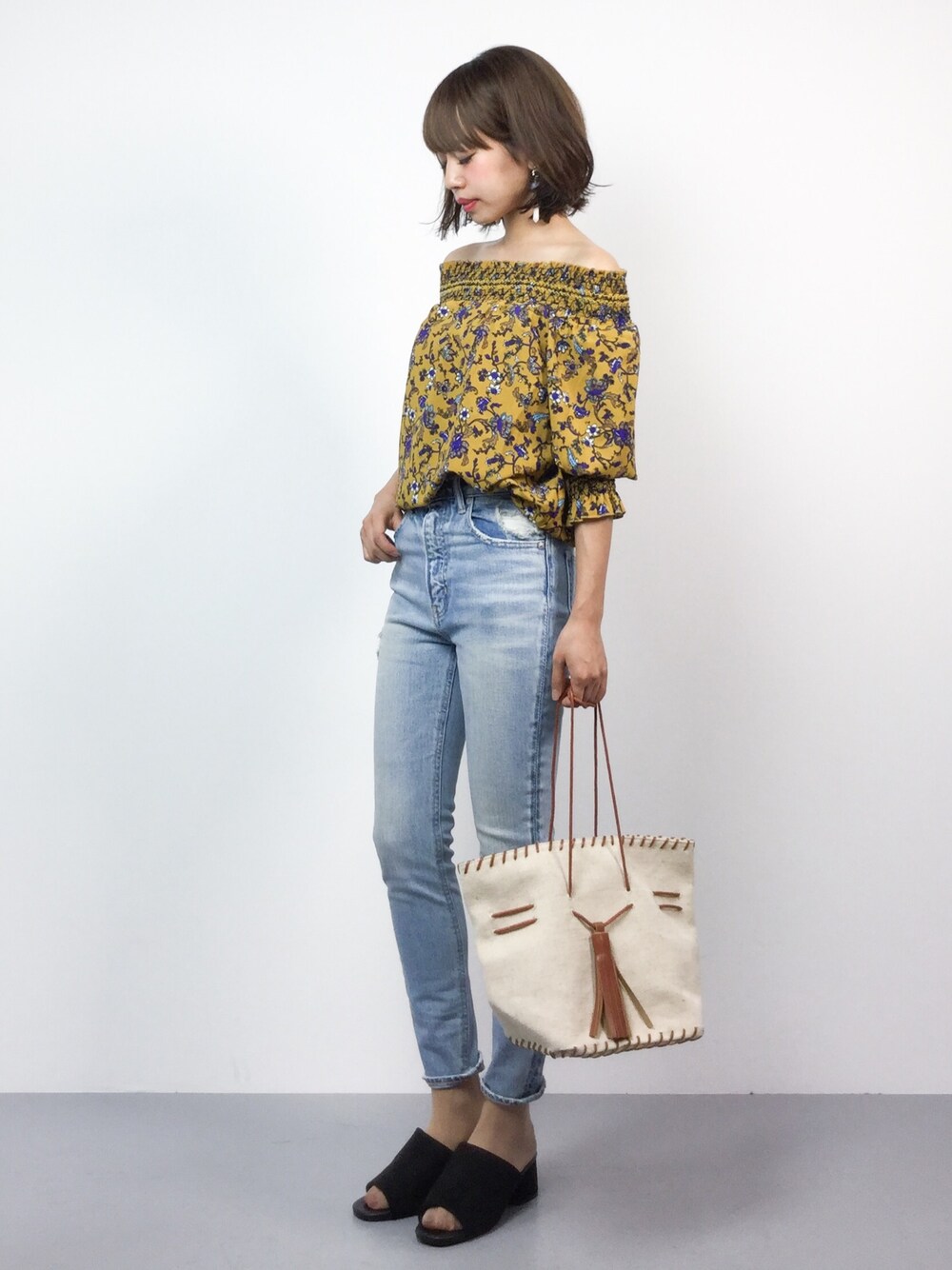 イエロー系のシャツ/ブラウス、ブルー系のデニムパンツ、ブラック系のサンダルを着用したレディースの夏コーディネートの1枚目の写真