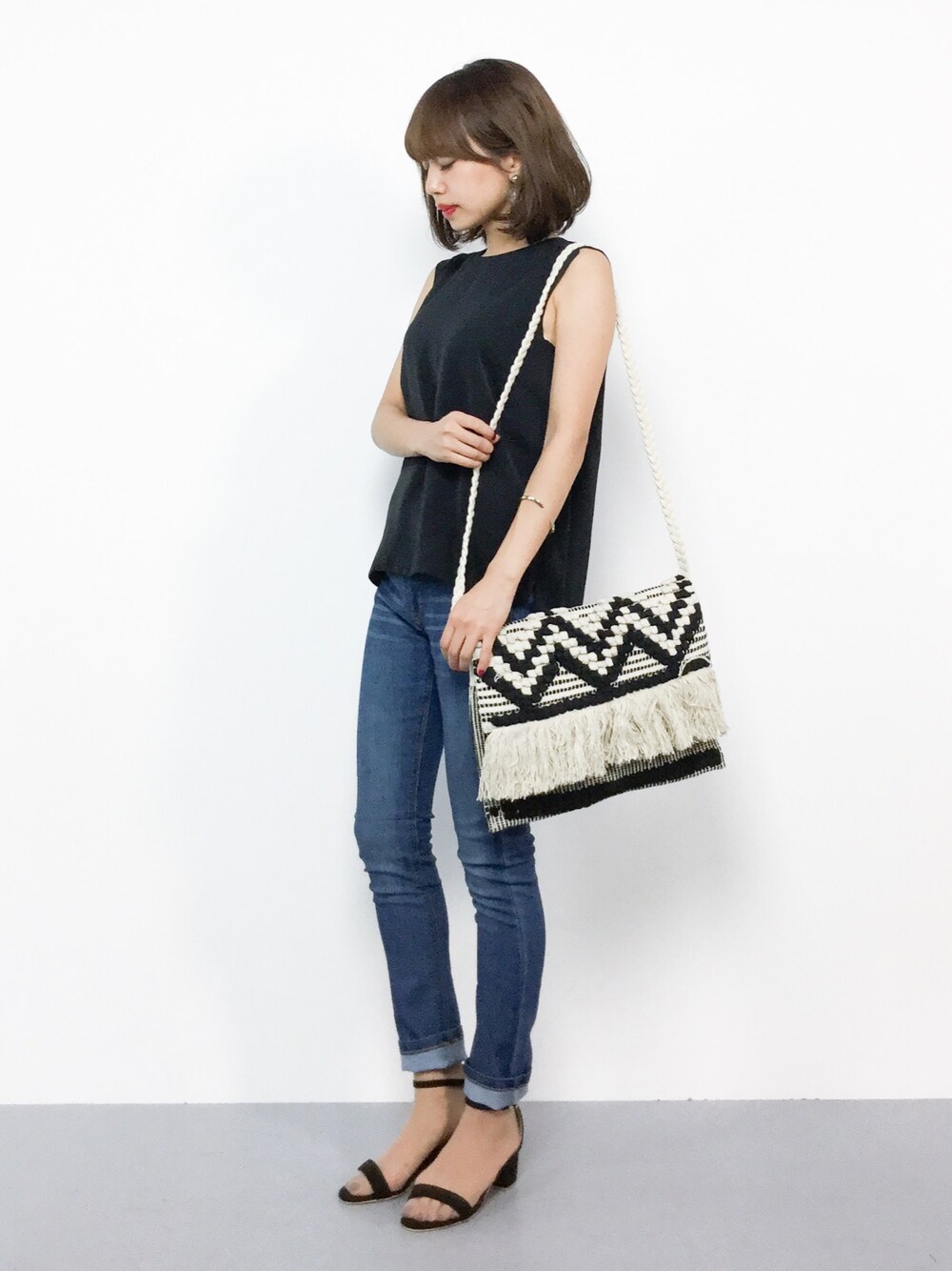 ブラック系のシャツ/ブラウス、ブルー系のデニムパンツ、ブラック系のサンダルを着用したレディースの夏コーディネートの1枚目の写真