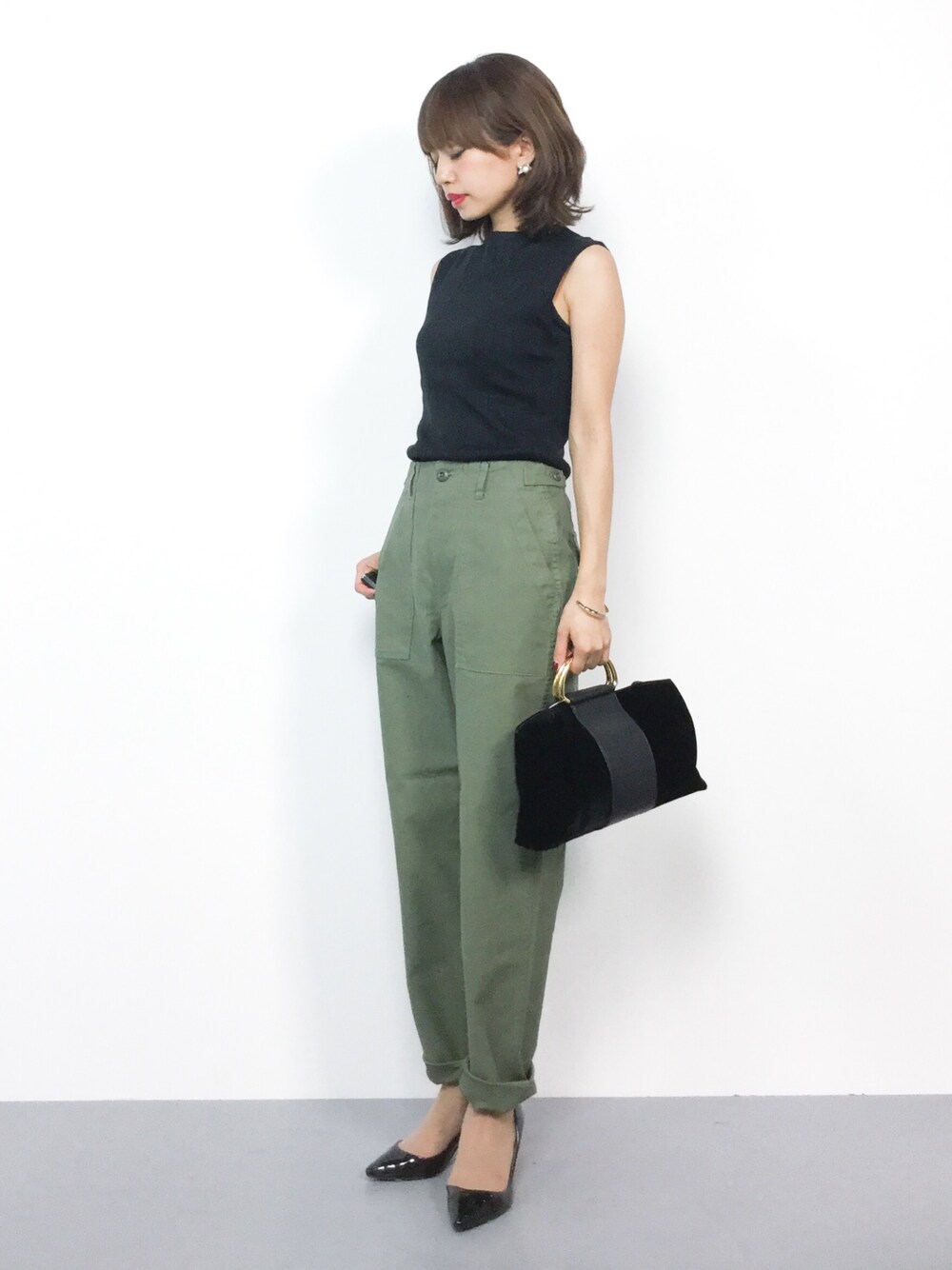 ブラック系のニット/セーター、グリーン系のその他パンツ、ブラック系のショルダーバッグを着用したレディースの夏コーディネートの1枚目の写真