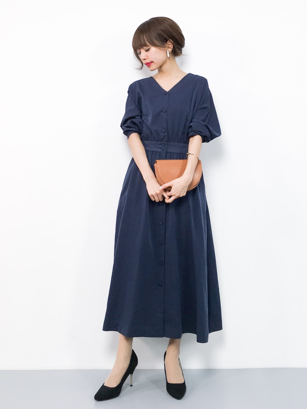 ブルー系のワンピース、イエロー系のボディバッグ/ウエストポーチを着用したレディースの春コーディネートの1枚目の写真