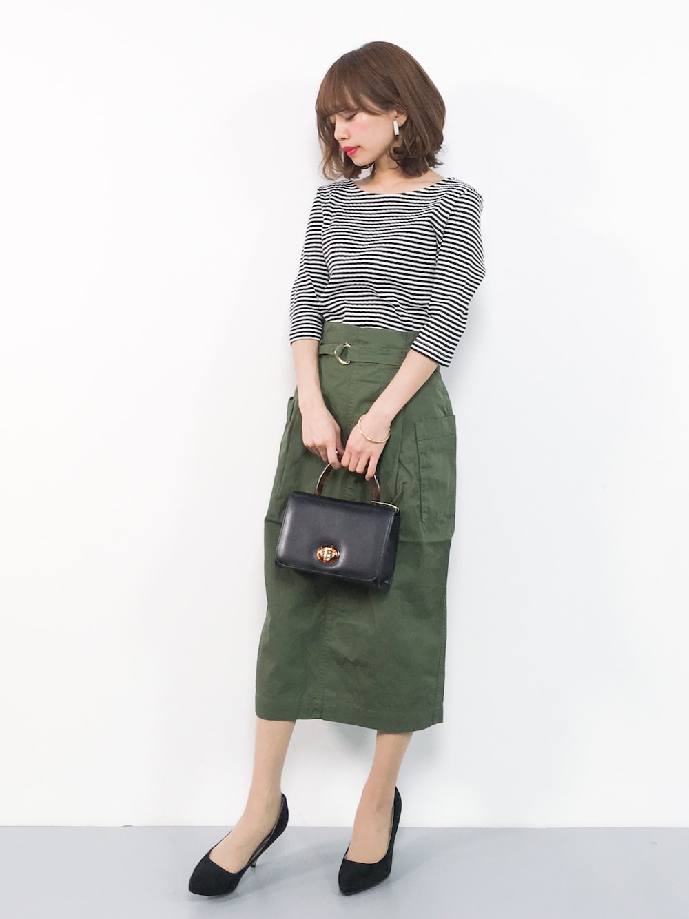 その他のTシャツ/カットソー、グリーン系のスカート、ブラック系のショルダーバッグを着用したレディースの春コーディネートの1枚目の写真