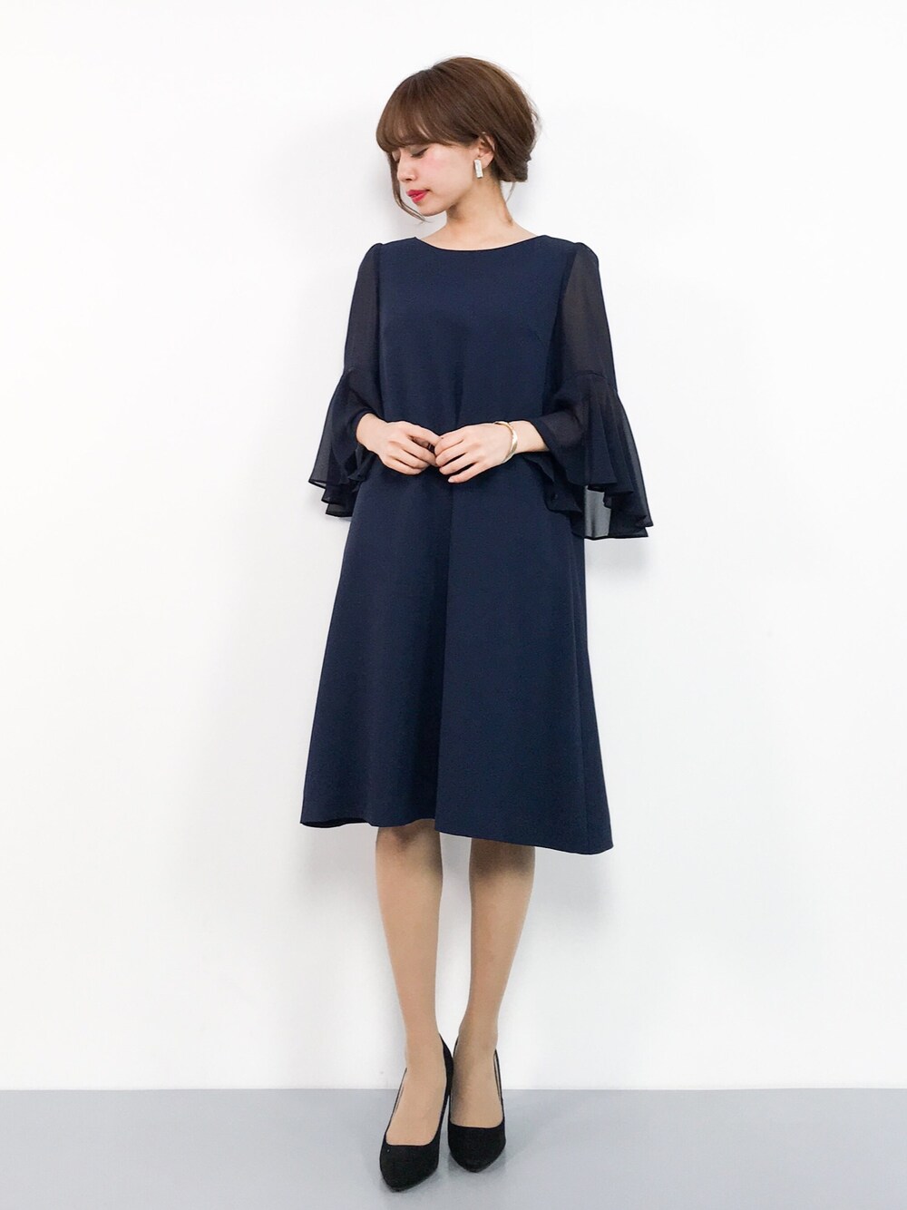 ブルー系のドレスを着用したレディースの春コーディネートの1枚目の写真