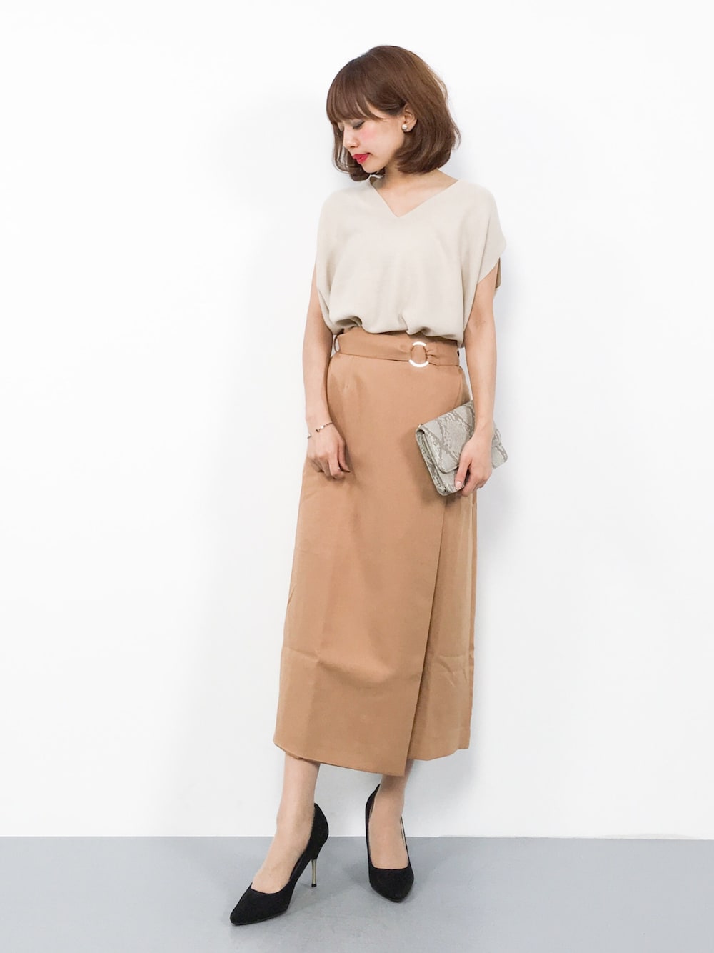 ホワイト系のニット/セーター、イエロー系のスカートを着用したレディースの夏コーディネートの1枚目の写真