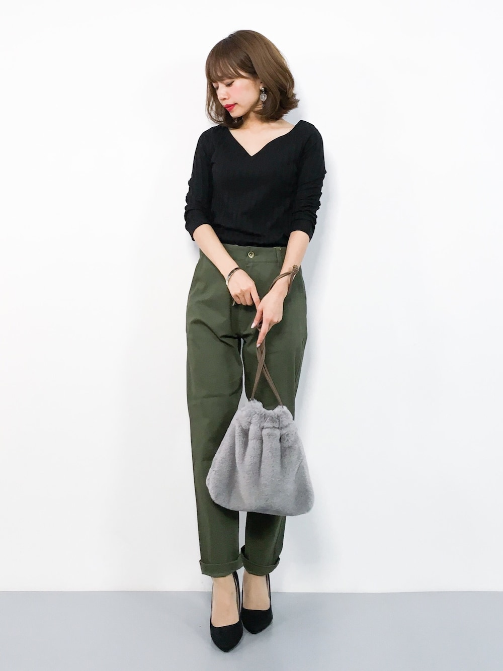 ブラック系のTシャツ/カットソー、グリーン系のチノパンツ、グレー系のショルダーバッグを着用したレディースの秋コーディネートの1枚目の写真