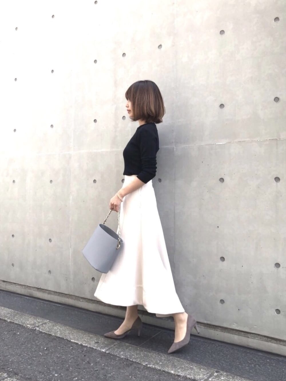 ホワイト系のスカート、ベージュ系のパンプス、ブルー系のショルダーバッグを着用したレディースの春コーディネートの1枚目の写真