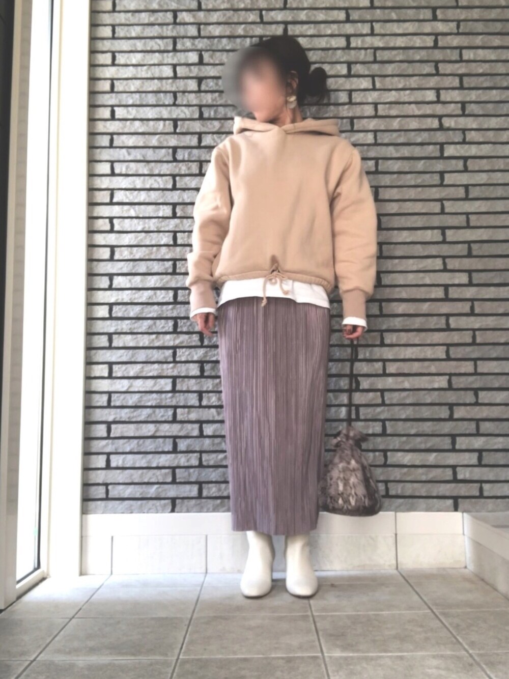 ホワイト系のブーツ、グレー系のスカート、ベージュ系のパーカーを着用したレディースの冬コーディネートの1枚目の写真