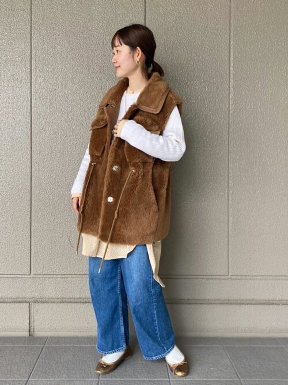 ブラウン系のその他アウター、ホワイト系のニット/セーター、ブルー系のデニムパンツを着用したレディースの冬コーディネートの1枚目の写真