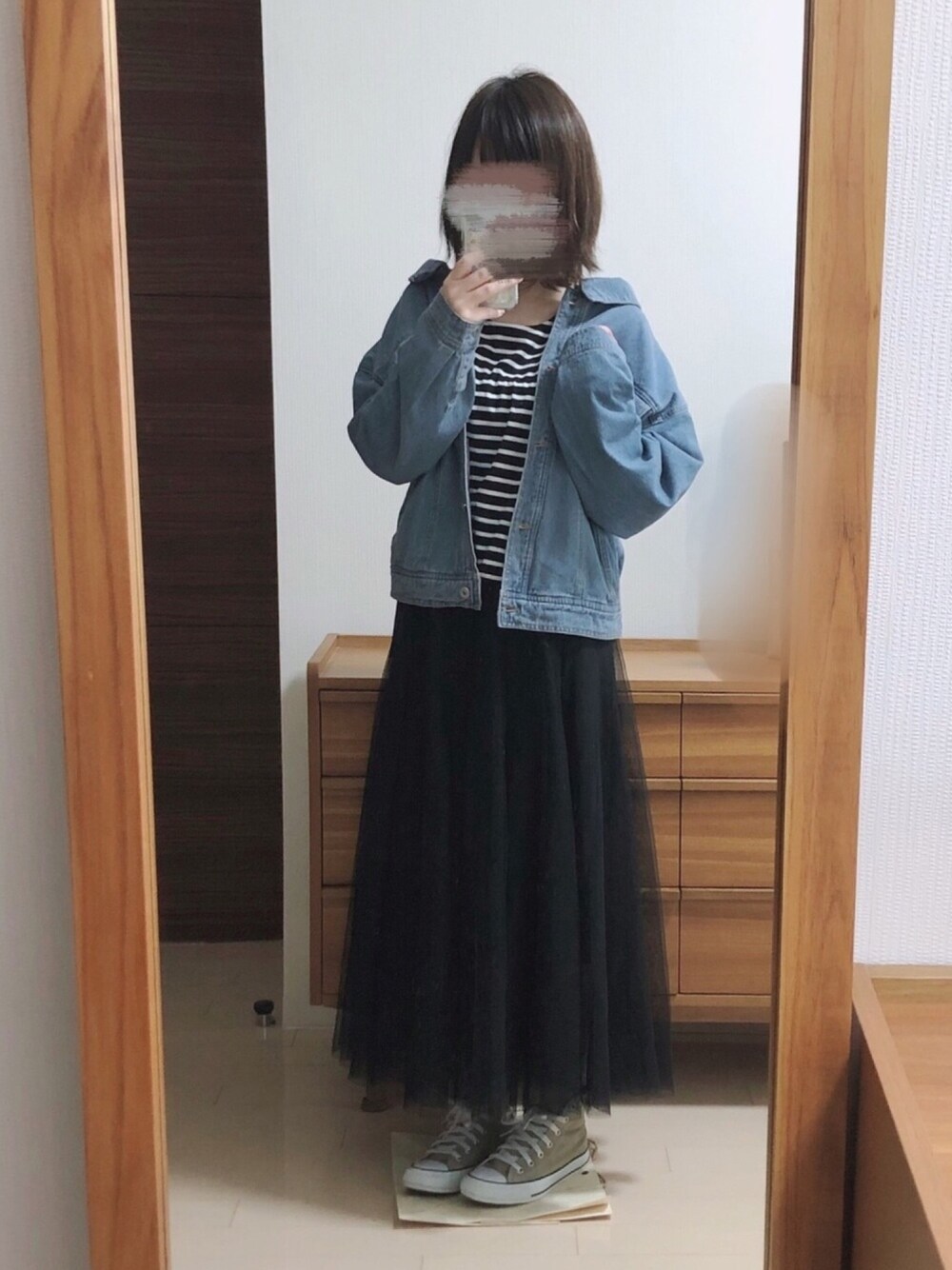 ブラック系のスカート、ベージュ系のスニーカー、ブラック系のTシャツ/カットソーを着用したレディースの春コーディネートの1枚目の写真