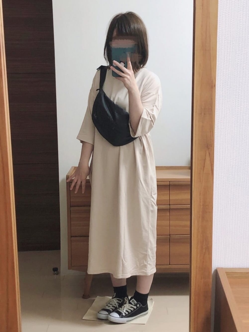 ベージュ系のワンピース、ブラック系のスニーカー、ブラック系のボディバッグ/ウエストポーチを着用したレディースの夏コーディネートの1枚目の写真