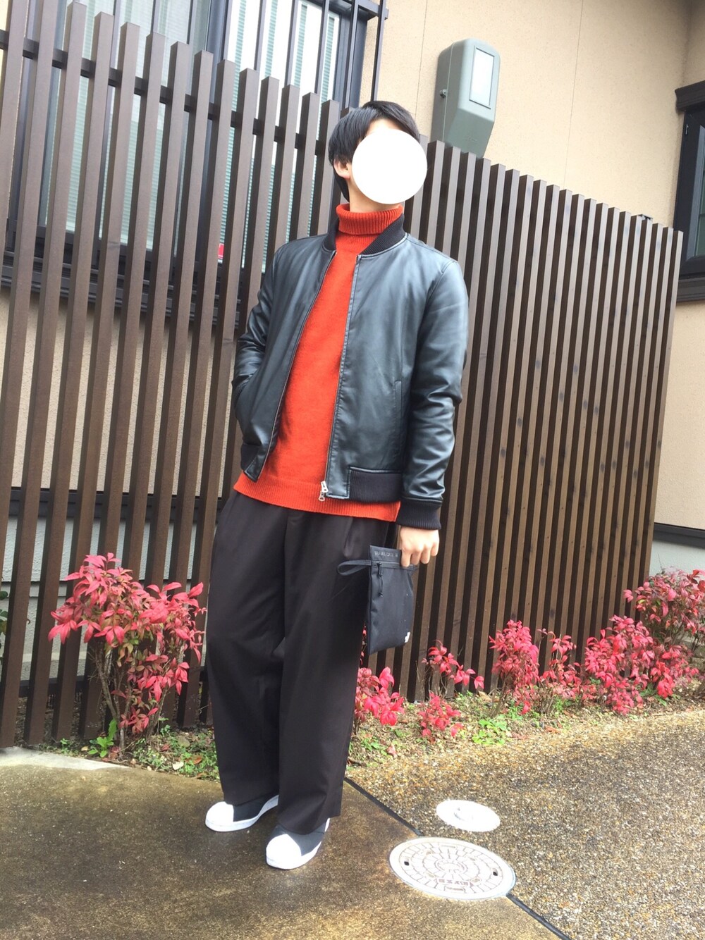 ブラック系のブルゾン、オレンジ系のニット/セーター、ブラック系のバッグを着用したメンズの冬コーディネートの1枚目の写真