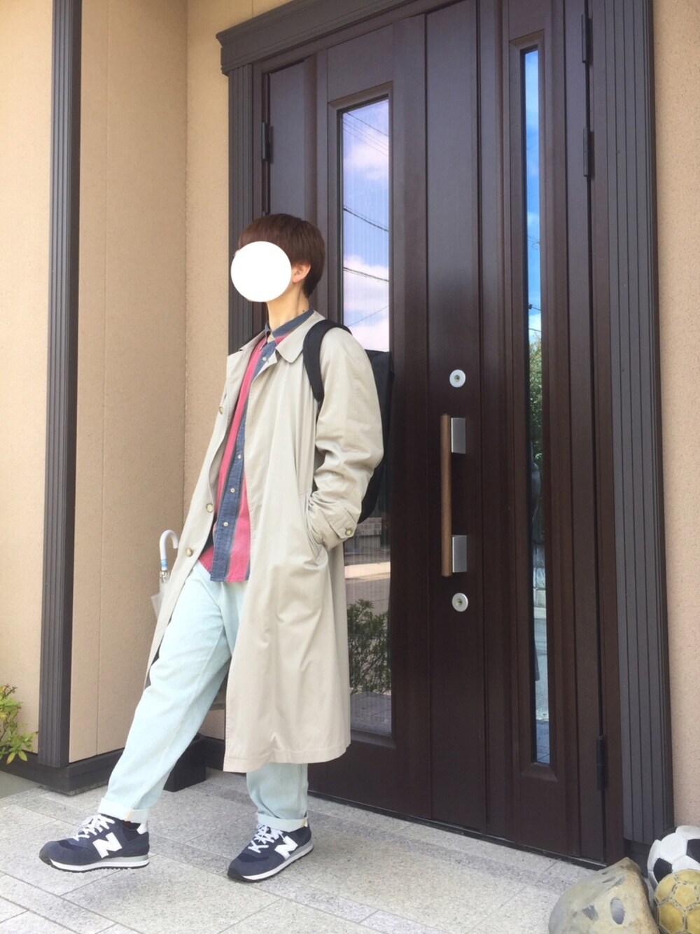 ベージュ系のステンカラーコート、レッド系のシャツ/ブラウス、ブラック系のバックパック/リュックを着用したメンズの春コーディネートの1枚目の写真