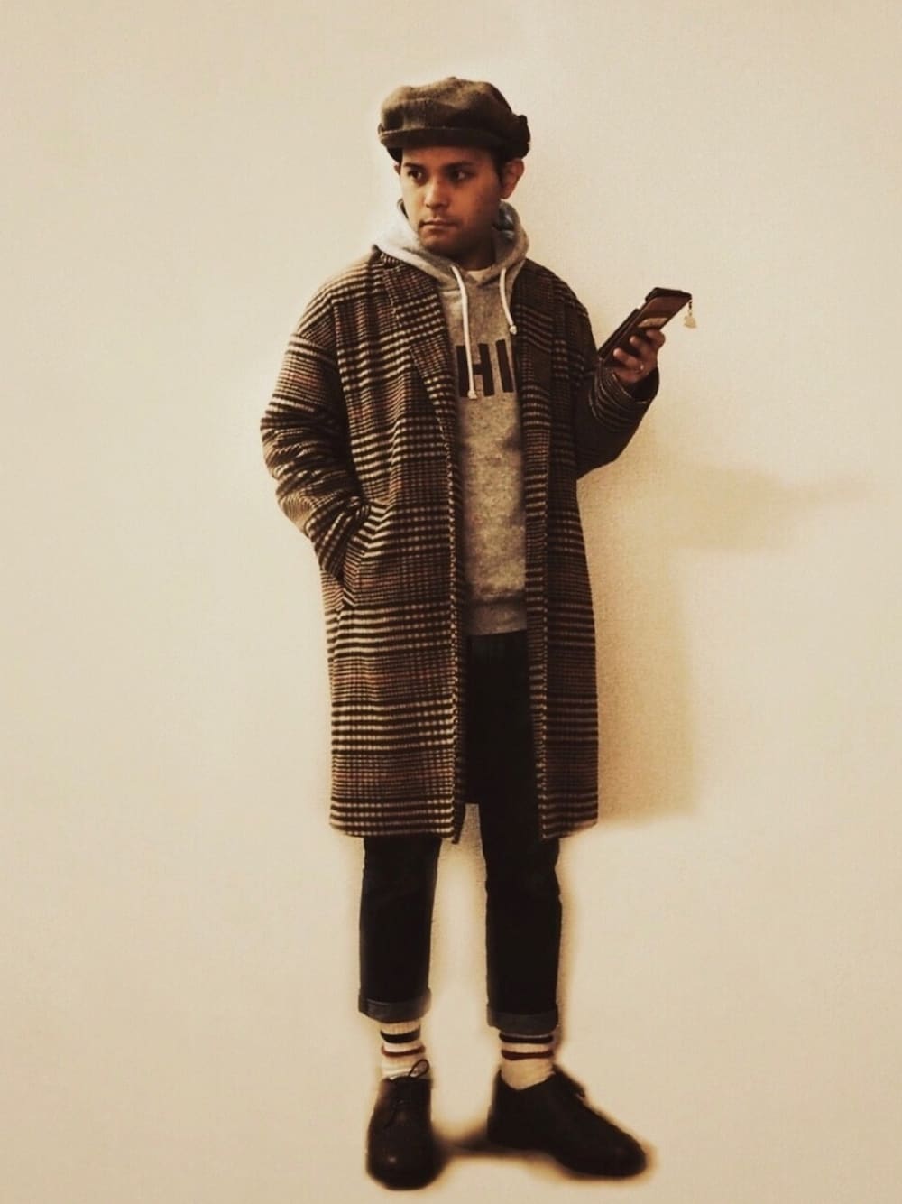 ブラウン系のチェスターコート、ブルー系のデニムパンツ、ブラウン系のドレスシューズを着用したメンズの冬コーディネートの1枚目の写真