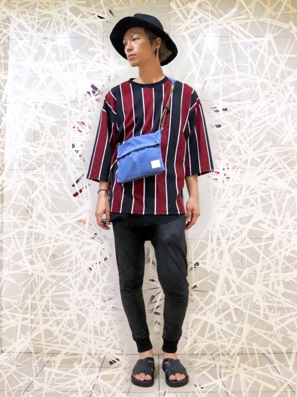 「ハット、ビッグT、ストライプ、サコッシュ、サンダル、黒パンツ」｜「SEVENDAYS=SUNDAYのUSC THAMO WIDE BRIM HAT（ハット、ブラック系）」を使った、テルジ ヨシザワさん（メンズ・180cm）の夏コーディネートの1枚目の写真