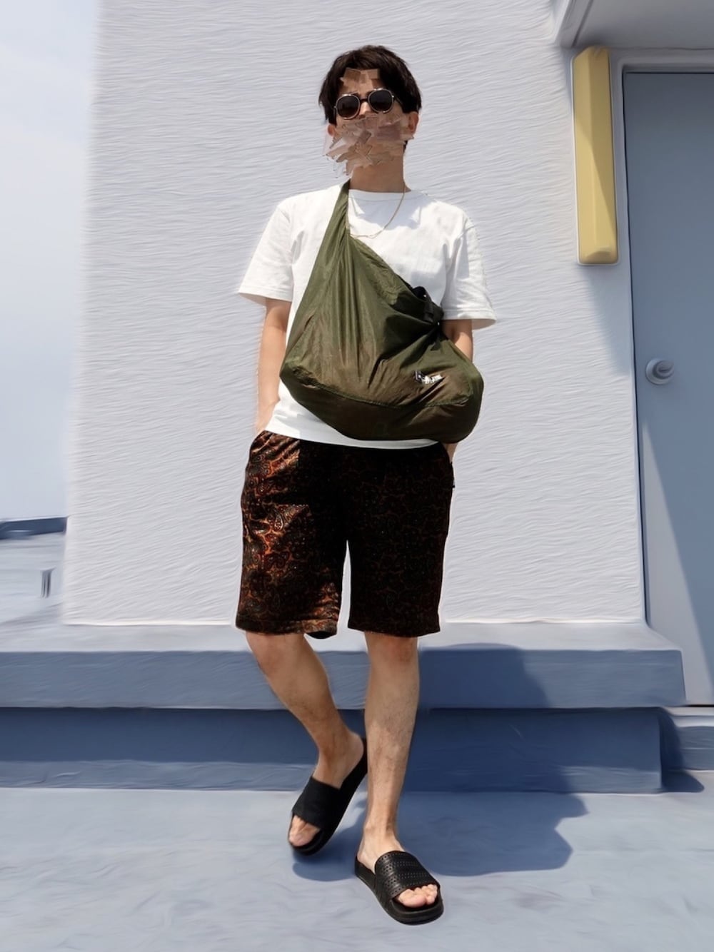 ブラウン系のその他パンツ、グリーン系のトートバッグ、ブラック系のサンダルを着用したメンズの夏コーディネートの1枚目の写真