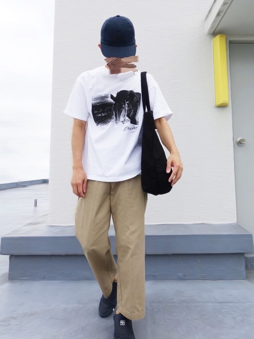 ホワイト系のTシャツ/カットソー、ベージュ系のチノパンツ、ブルー系のスニーカーを着用したメンズの秋コーディネートの1枚目の写真