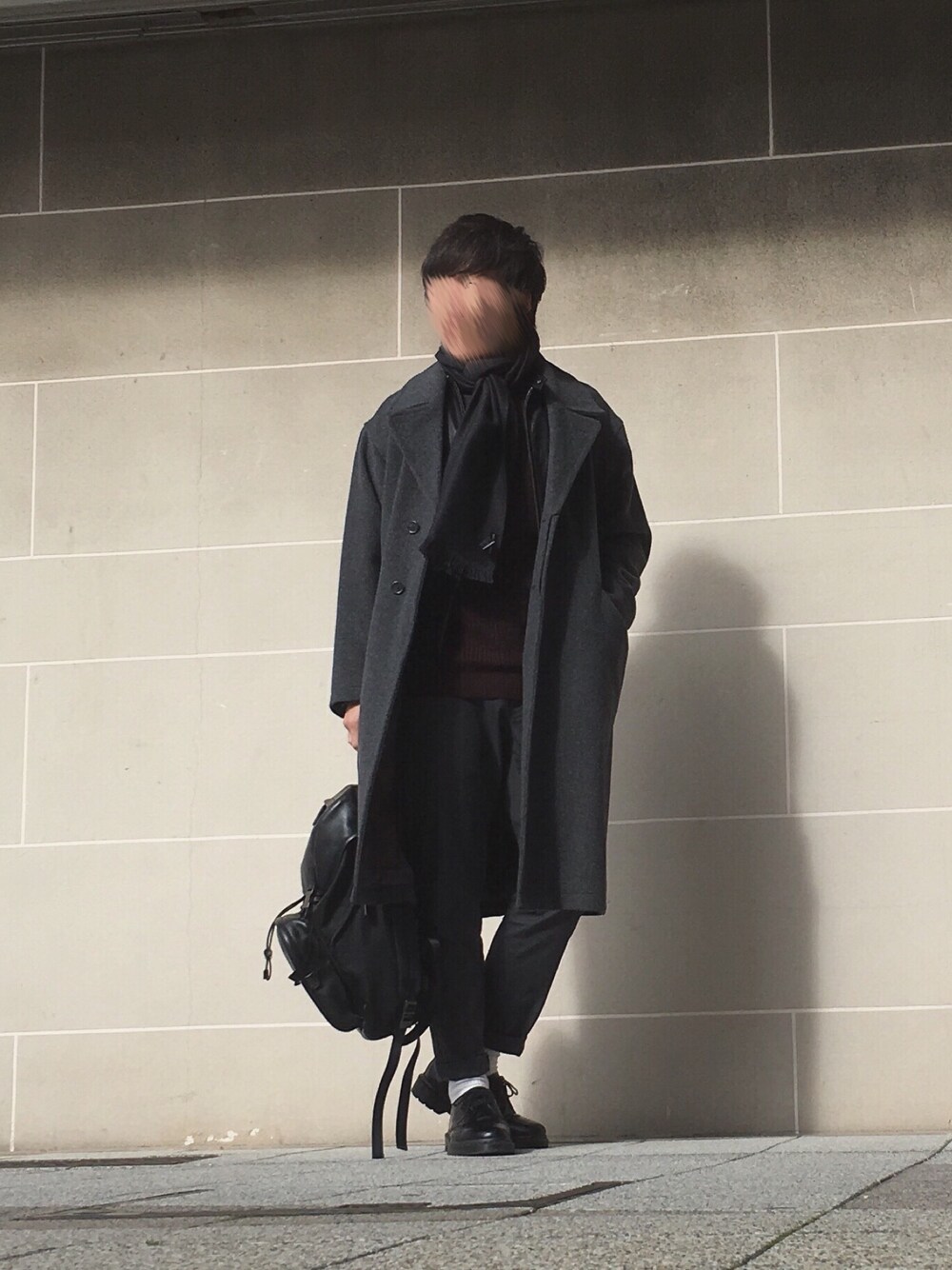 グレー系のトレンチコート、ブラック系のライダースジャケット、ブラウン系のニット/セーターを着用したメンズの冬コーディネートの1枚目の写真