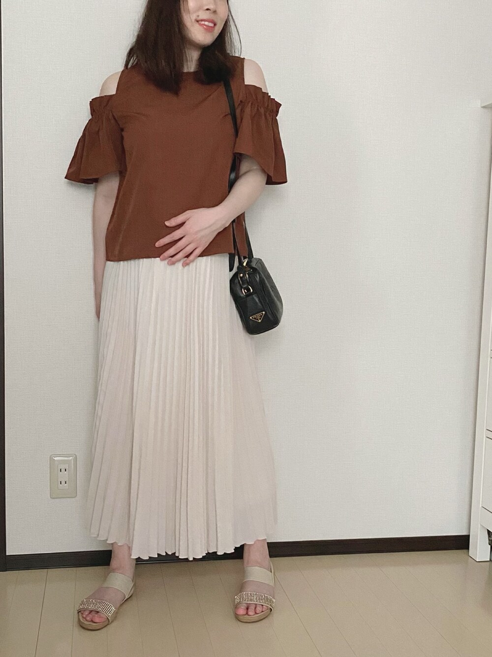 ベージュ系のスカート、ブラウン系のシャツ/ブラウス、ブラック系のショルダーバッグを着用したレディースの夏コーディネートの1枚目の写真