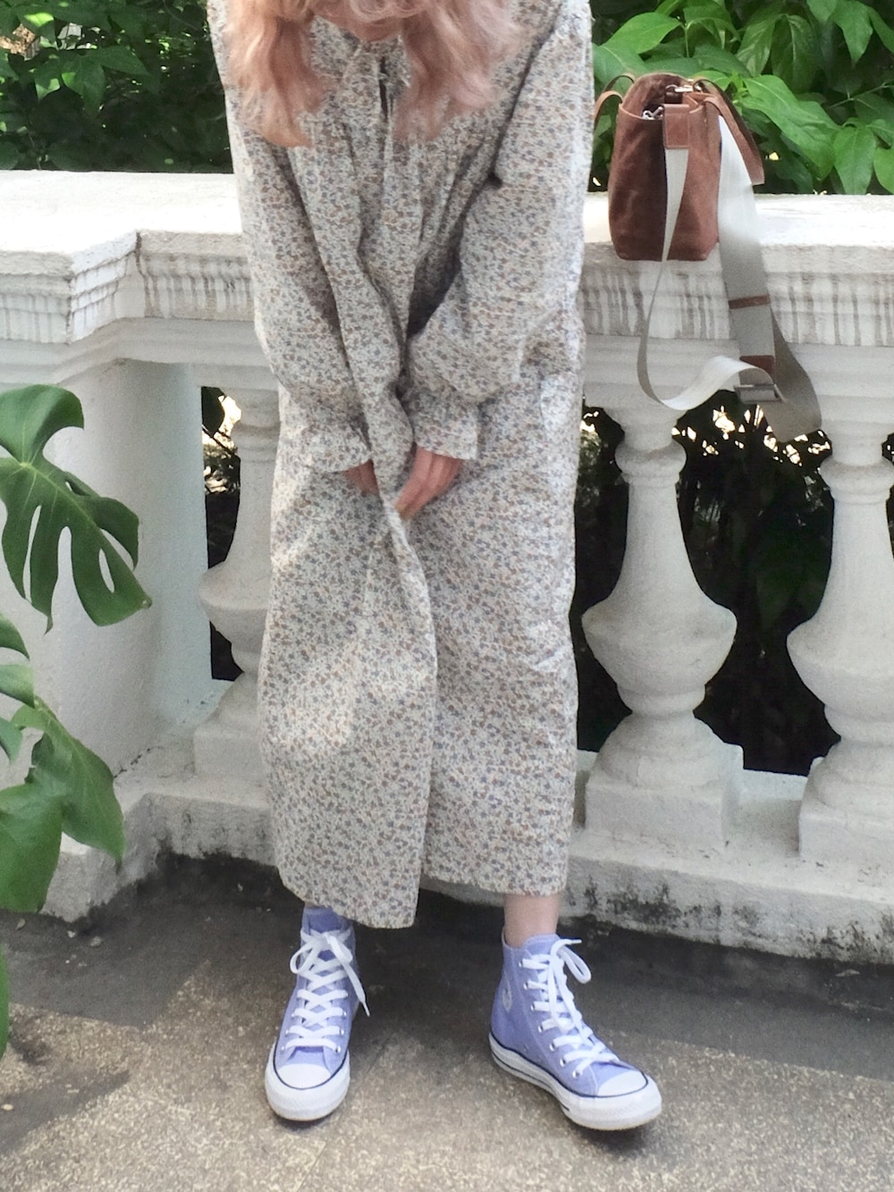 ブラウン系のハンドバッグ、パープル系のスニーカーを着用したレディースの春コーディネートの1枚目の写真